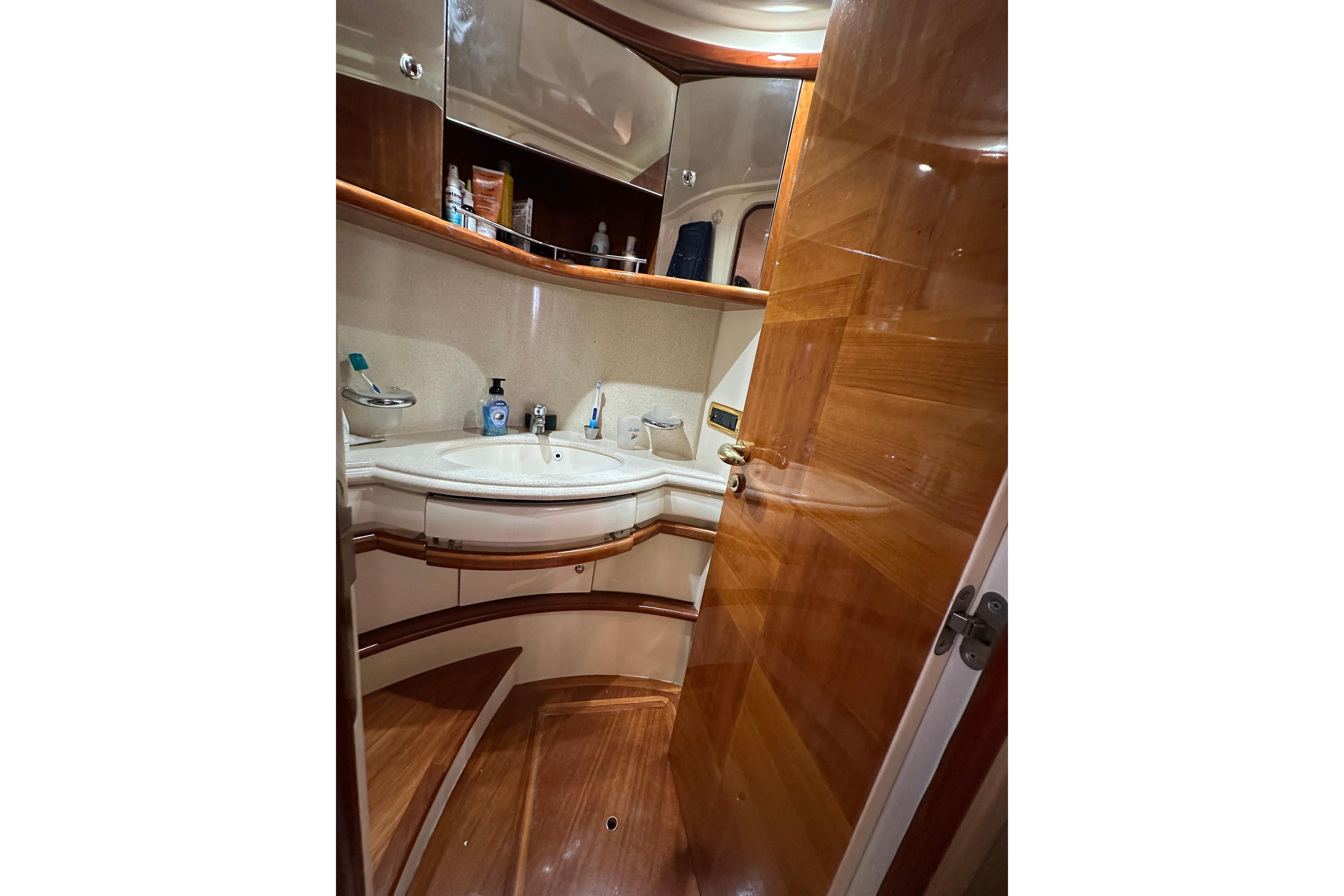 Luxurious bathroom interior of 2004 Azimut 55E yacht with wooden finishes.