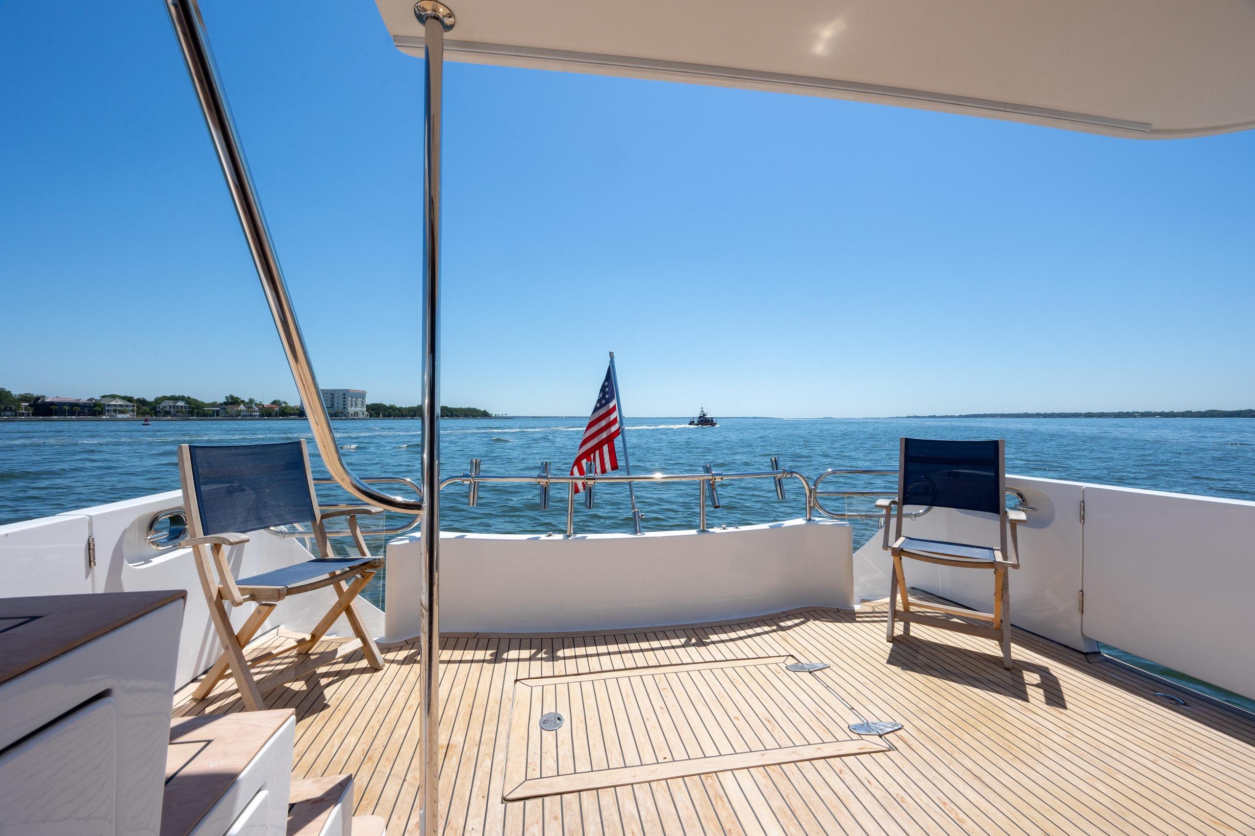 Ocean Alexander 52 Sedan 2005 yacht deck with chairs, ocean view, and American flag.