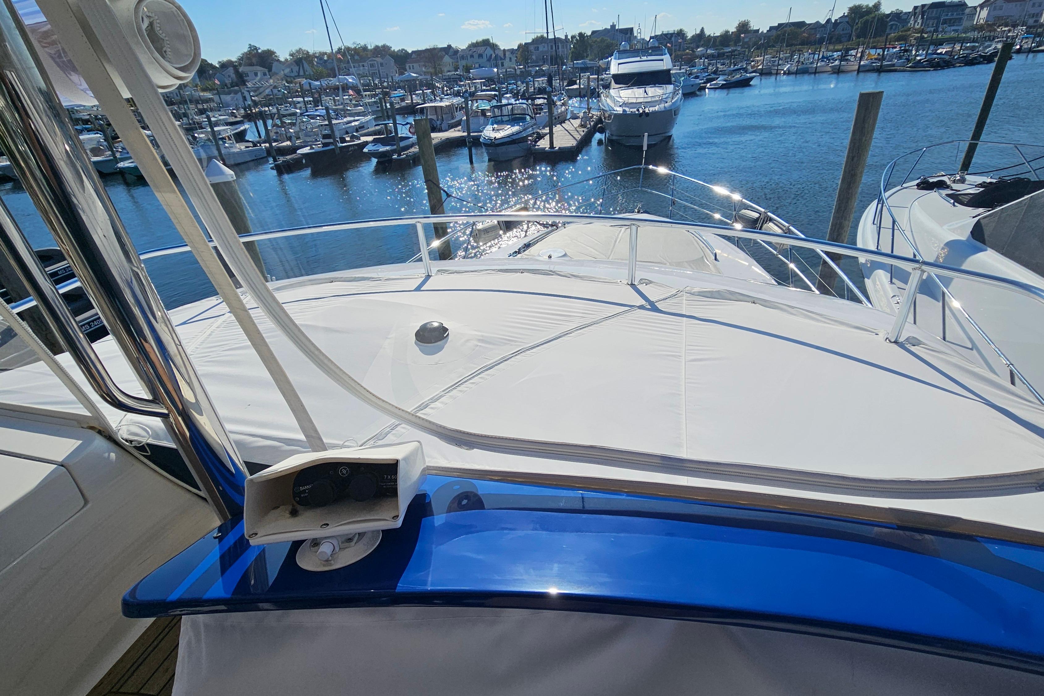 2005 Neptunus 56 Flybridge yacht docked at a marina under sunny skies.