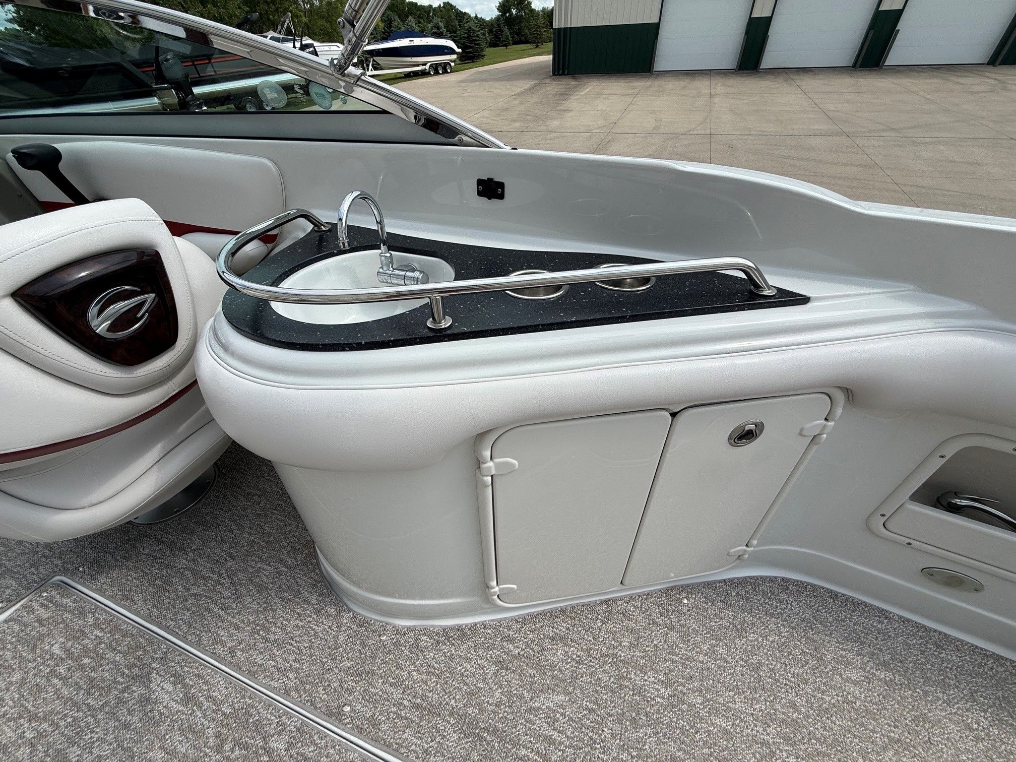 The image shows the cockpit of a 2012 Crownline 252 EX with a small sink.