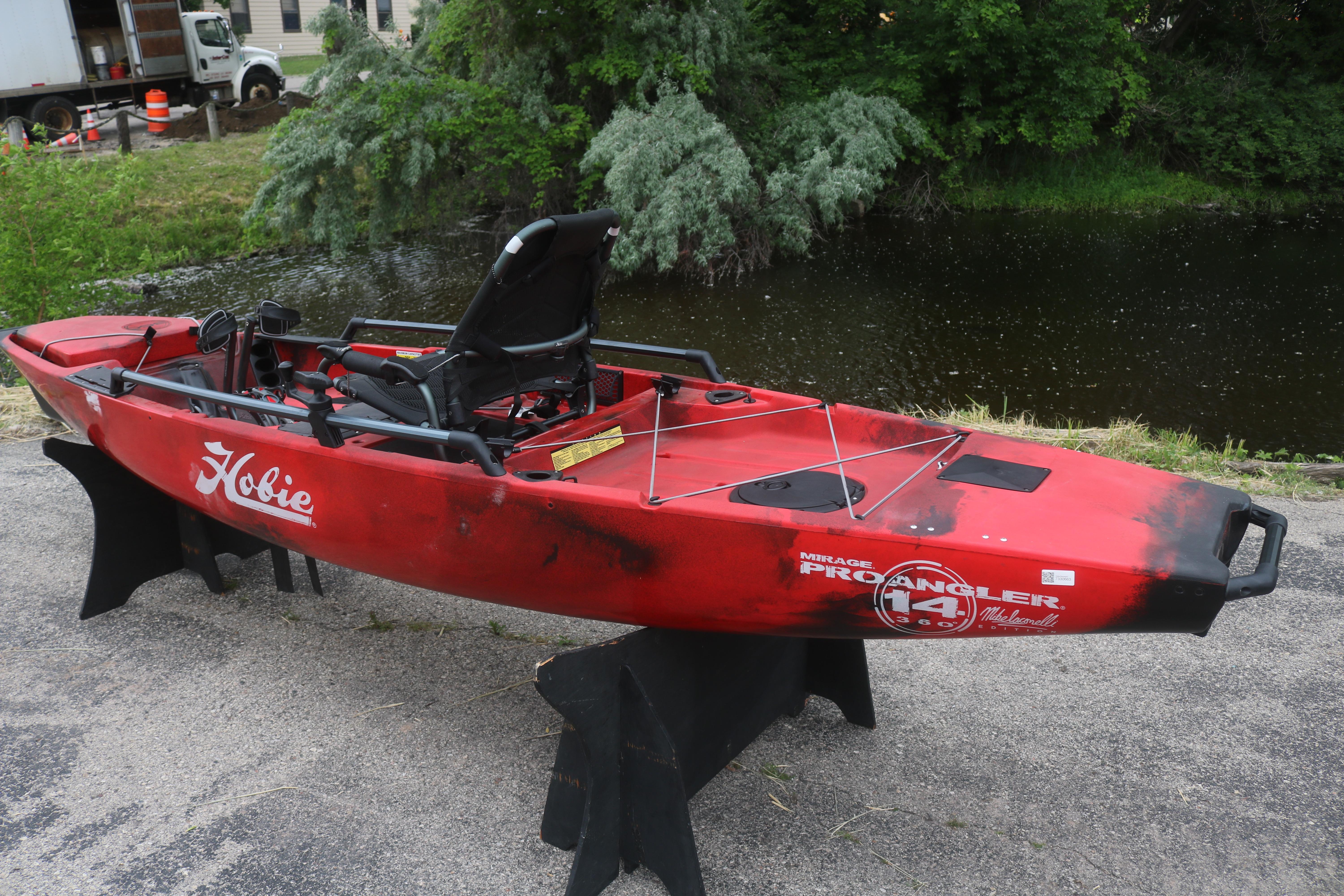 Red 2023 Hobie Mirage Pro Angler 14 kayak displayed near a pond.