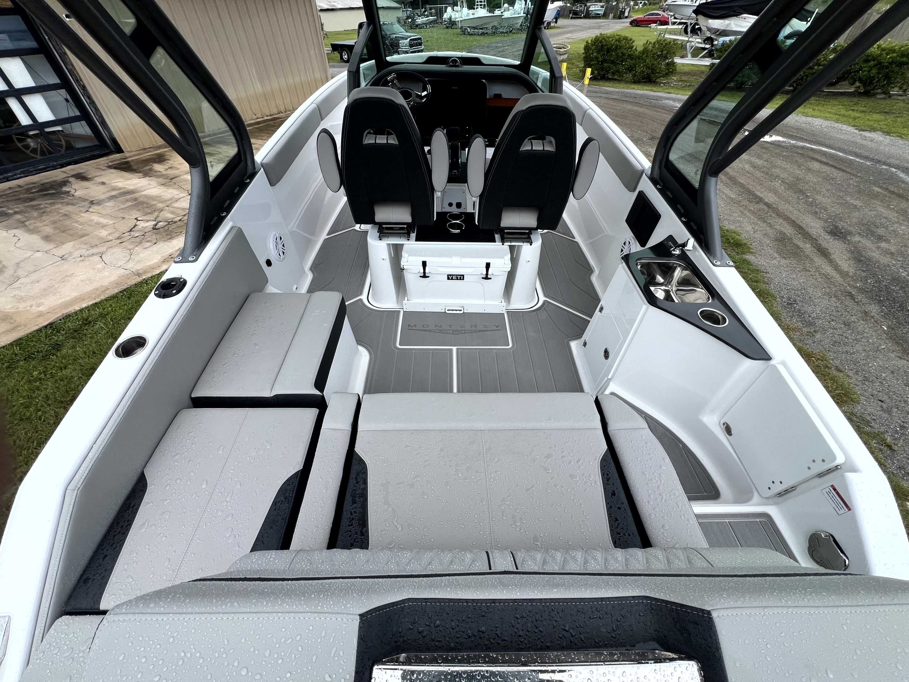 The image shows the cockpit of a 2026 Monterey Elite 25 boat with gray upholstery.