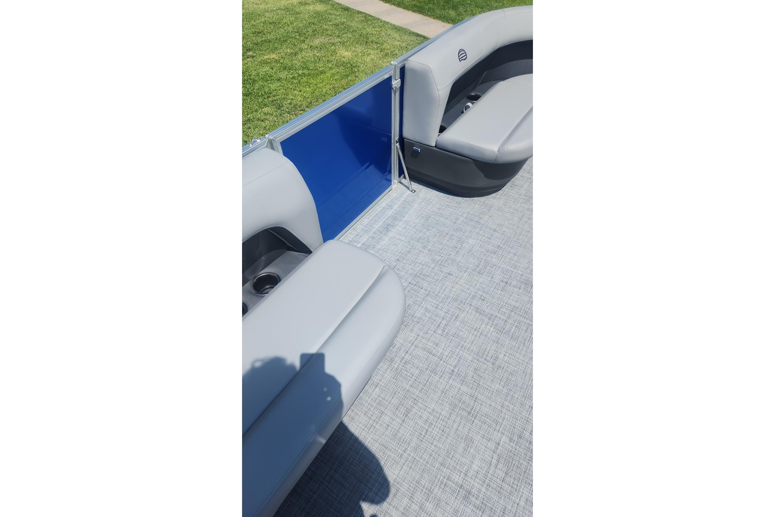 2026 Sun Tracker Party Barge 16 DLX interior with gray seating and blue panel.