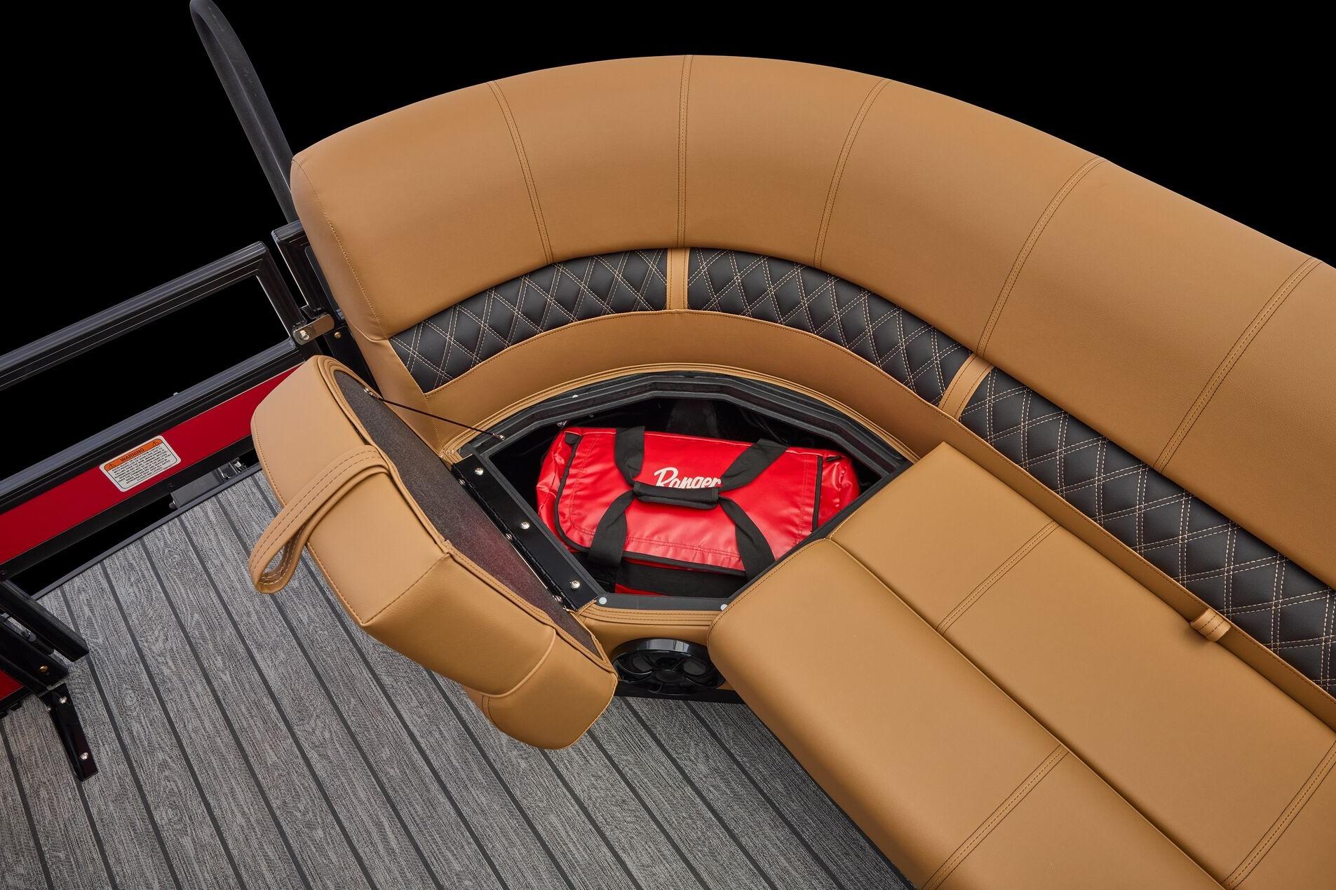 Luxurious seating with storage on 2026 Ranger 223FC boat, featuring tan and black upholstery.