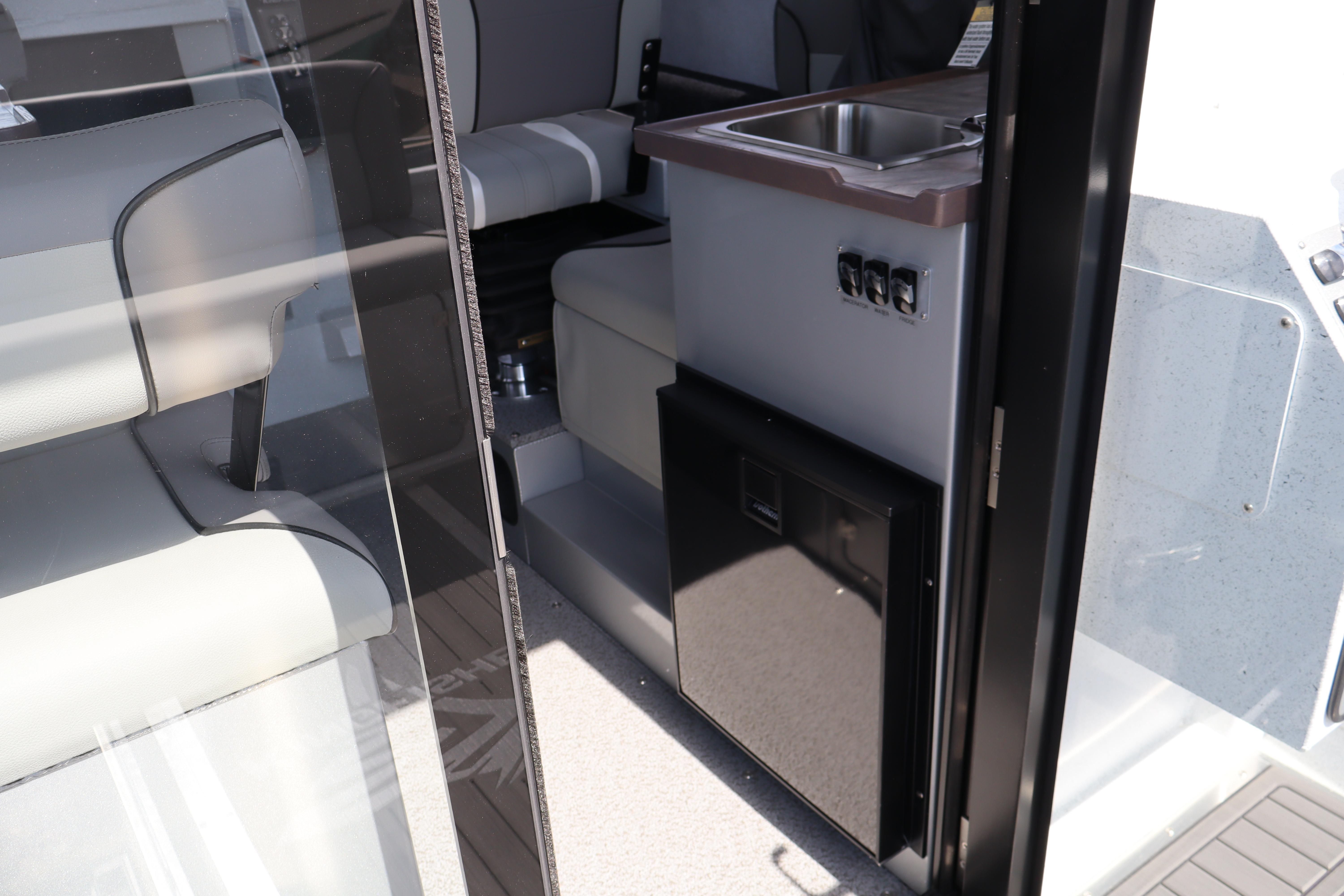 Interior view of 2026 KingFisher 25 XAC boat, featuring seating and compact kitchenette.