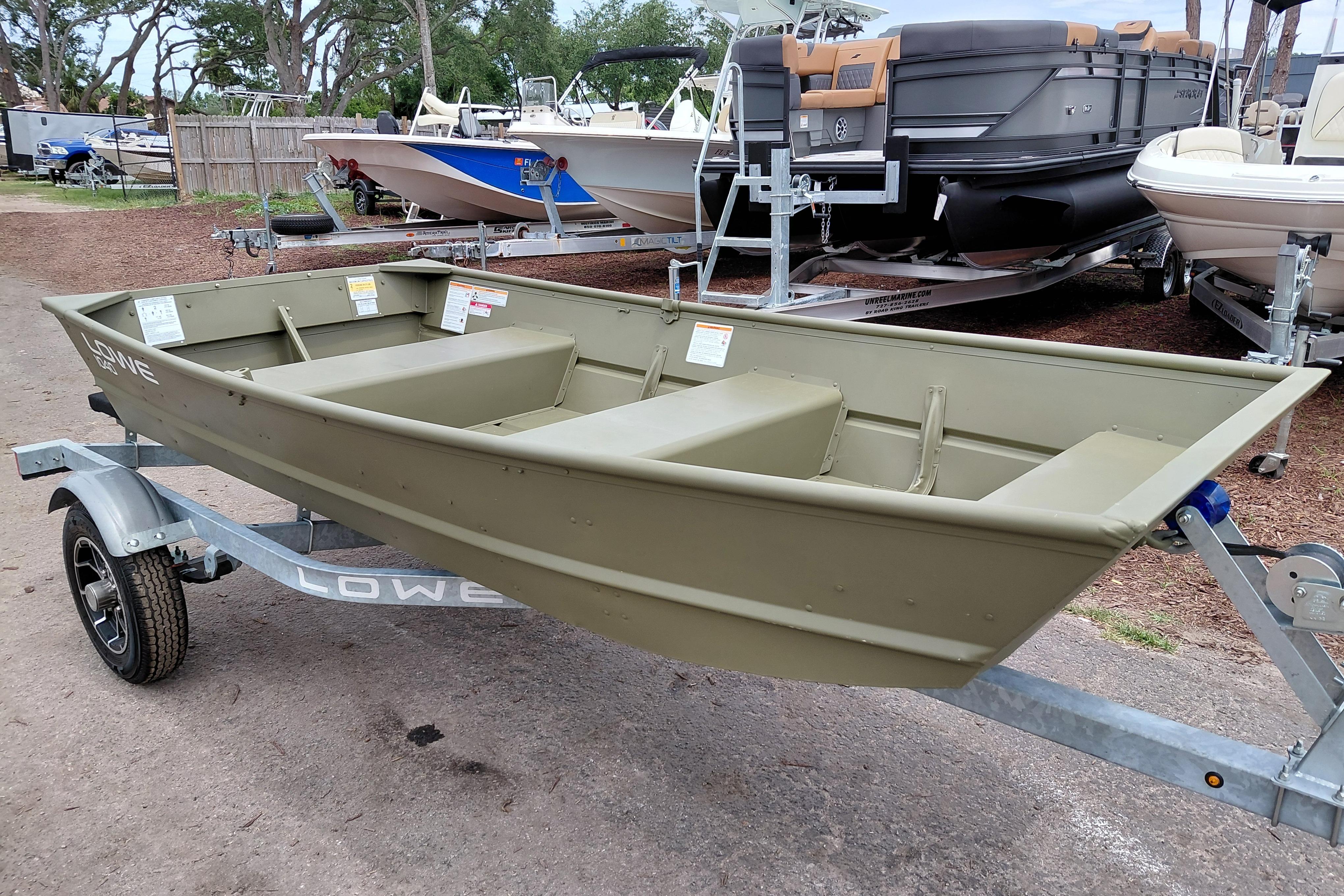 2025 Lowe L1040 Jon boat on trailer, surrounded by other boats in a yard.