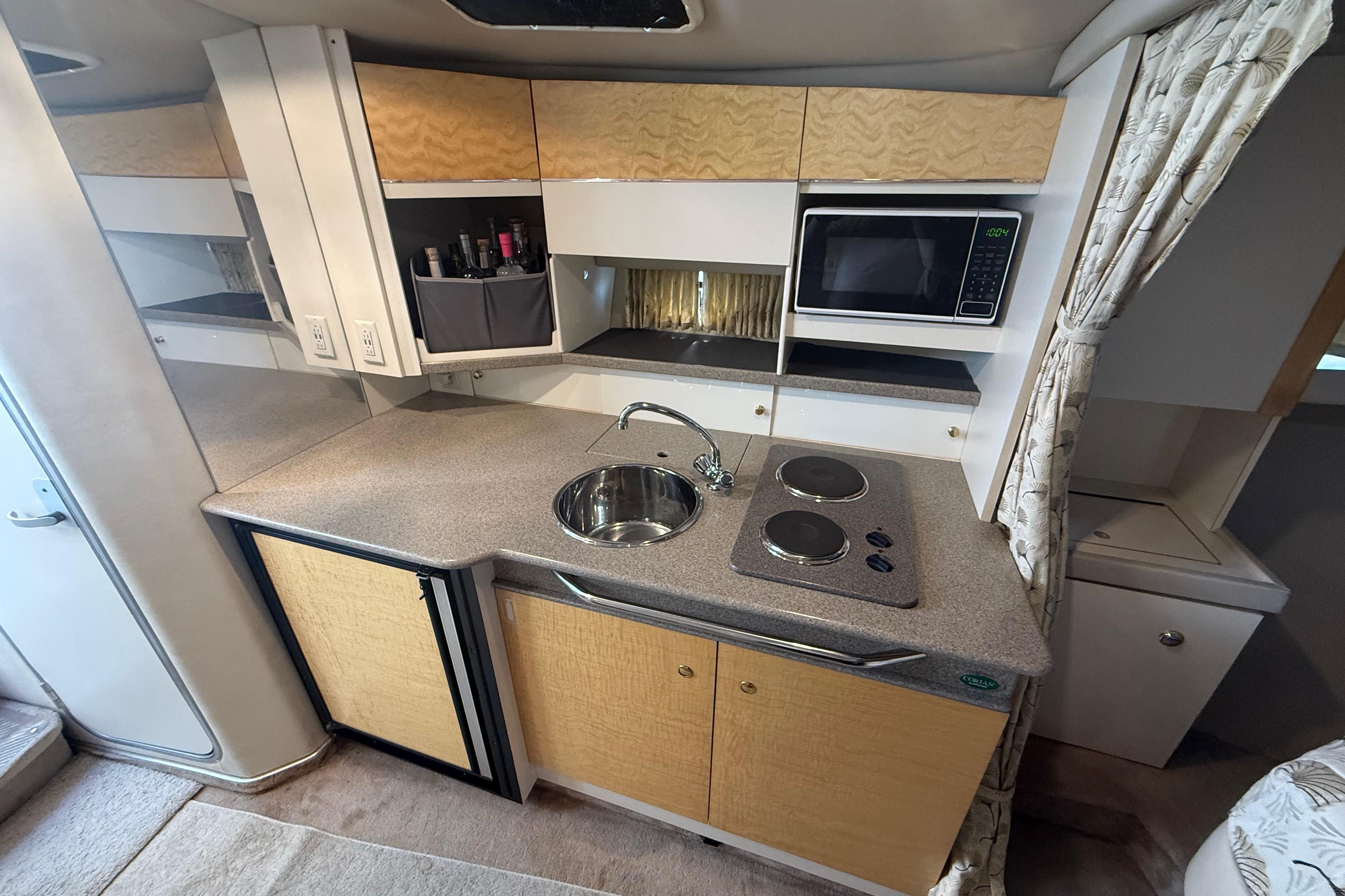 1999 Formula 34 Performance Cruiser kitchen with sink, stove, microwave, and storage cabinets.