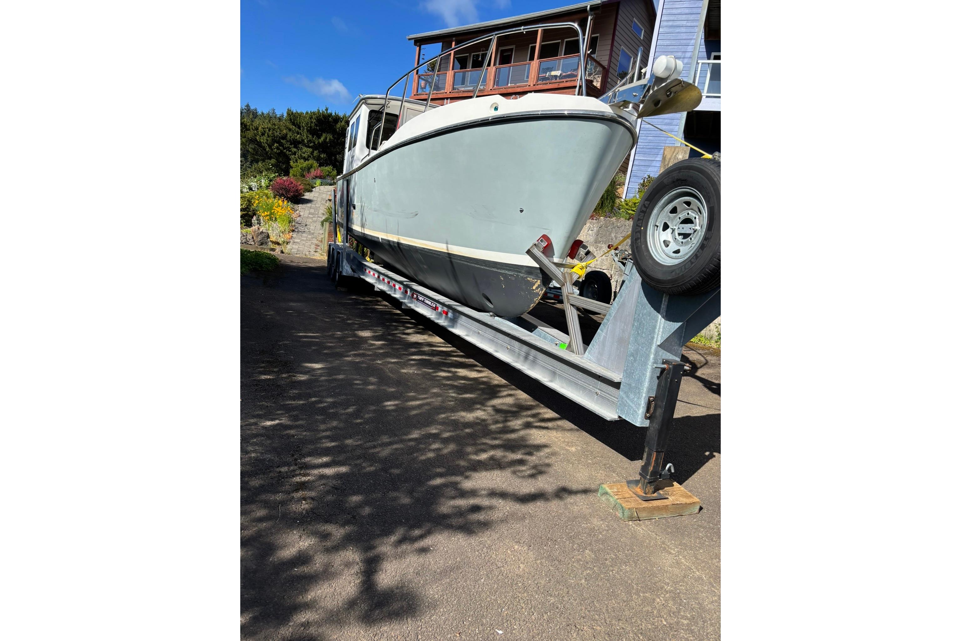 2020 SeaPiper 35 boat on trailer, parked outdoors near a house.