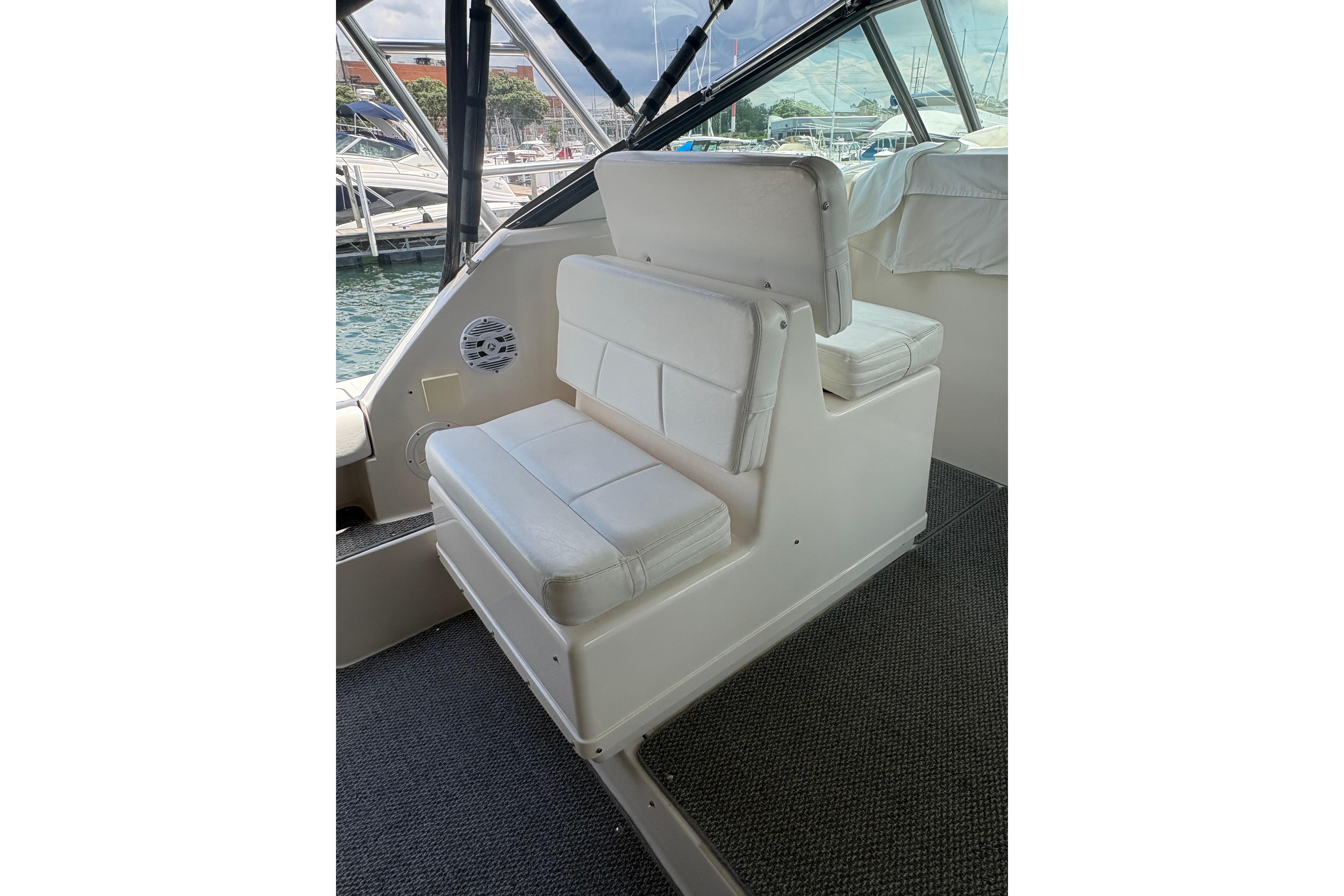 1999 Tiara Yachts 3100 Open interior seating with white cushions and marina view.