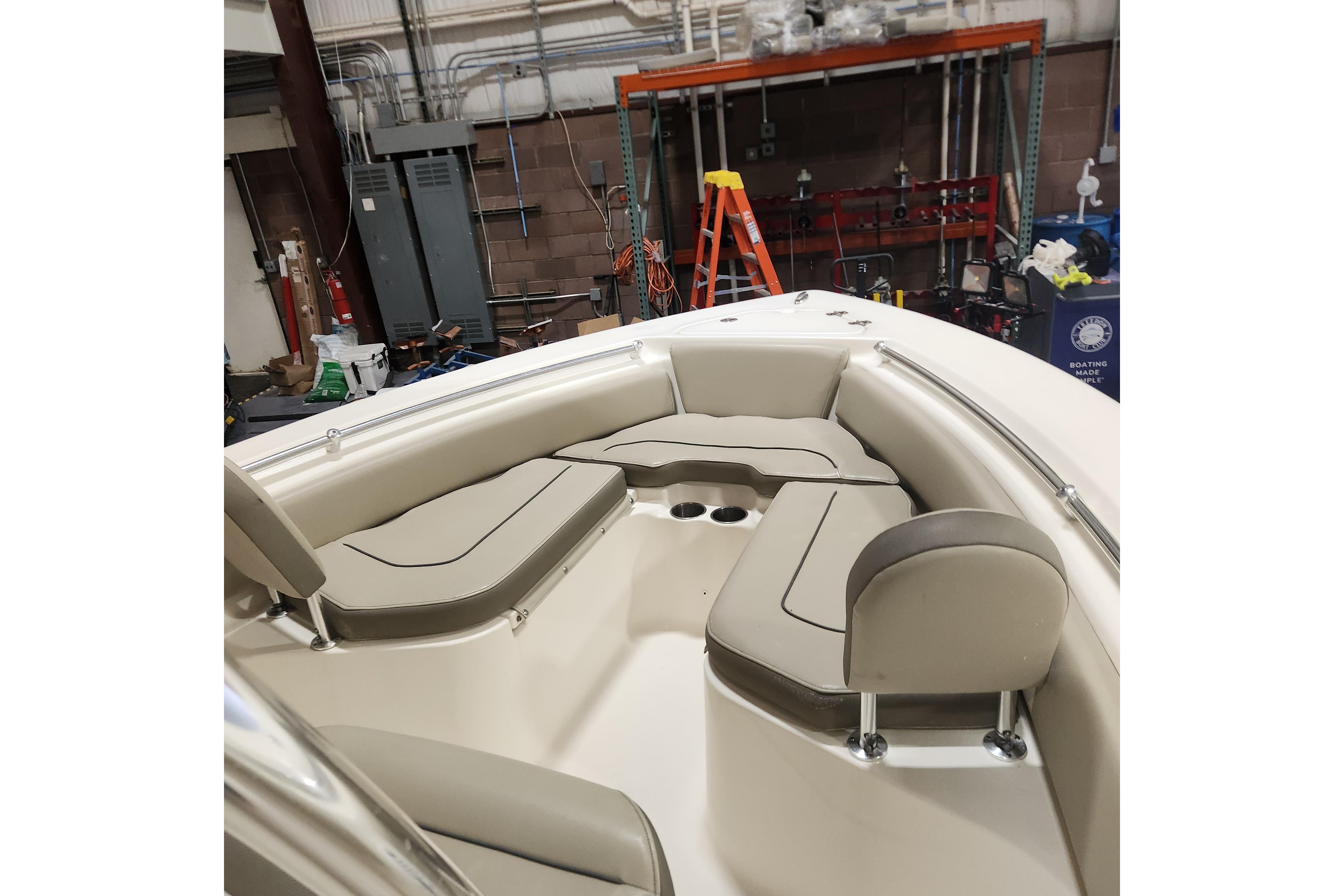 2023 Key West 219 FS boat interior with cushioned seating in a workshop setting.