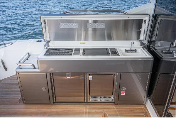 Outdoor kitchen on 2021 Riviera 5400 Sport Yacht with stainless steel appliances.