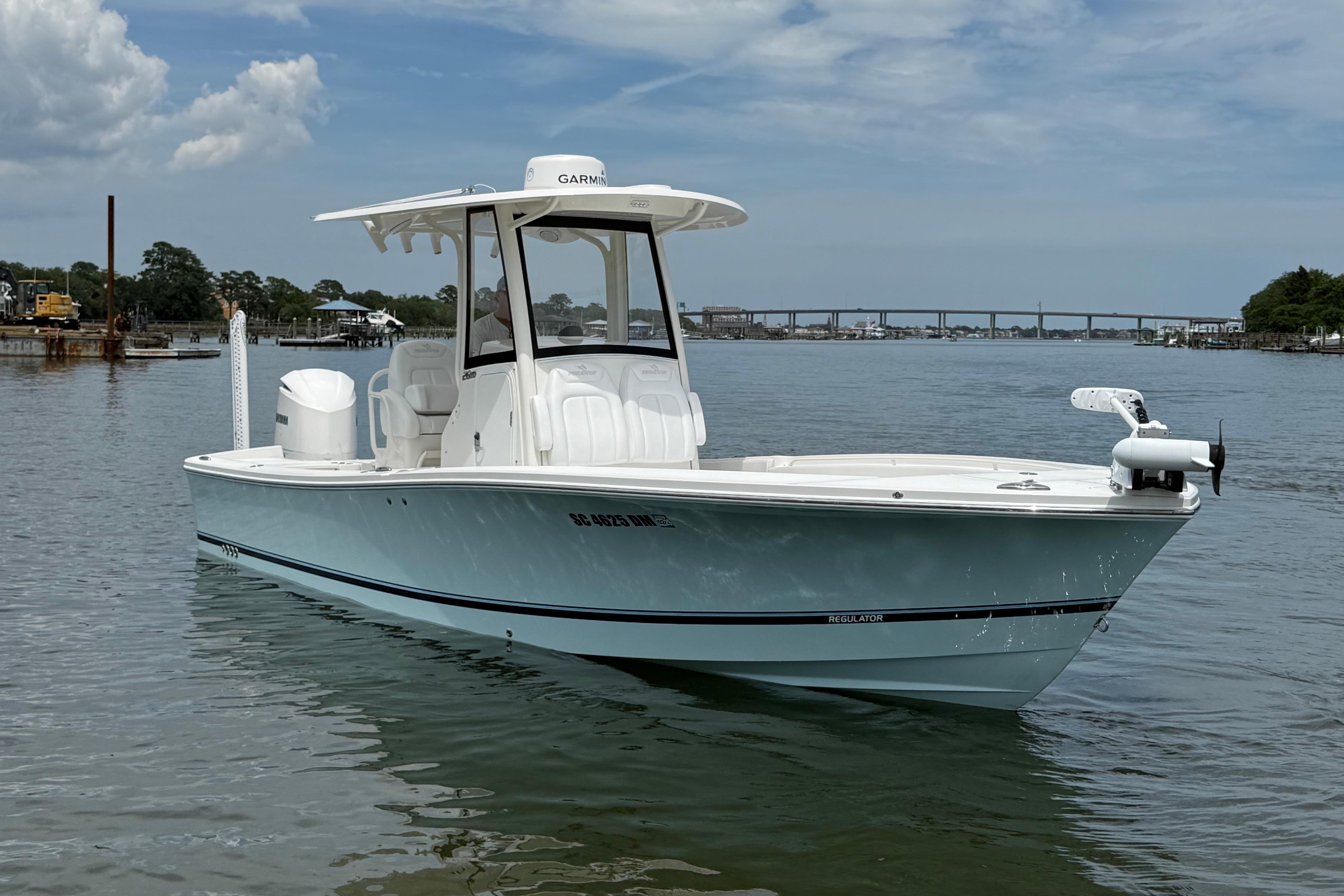 2019 Regulator 26XO boat on calm water under a partly cloudy sky.
