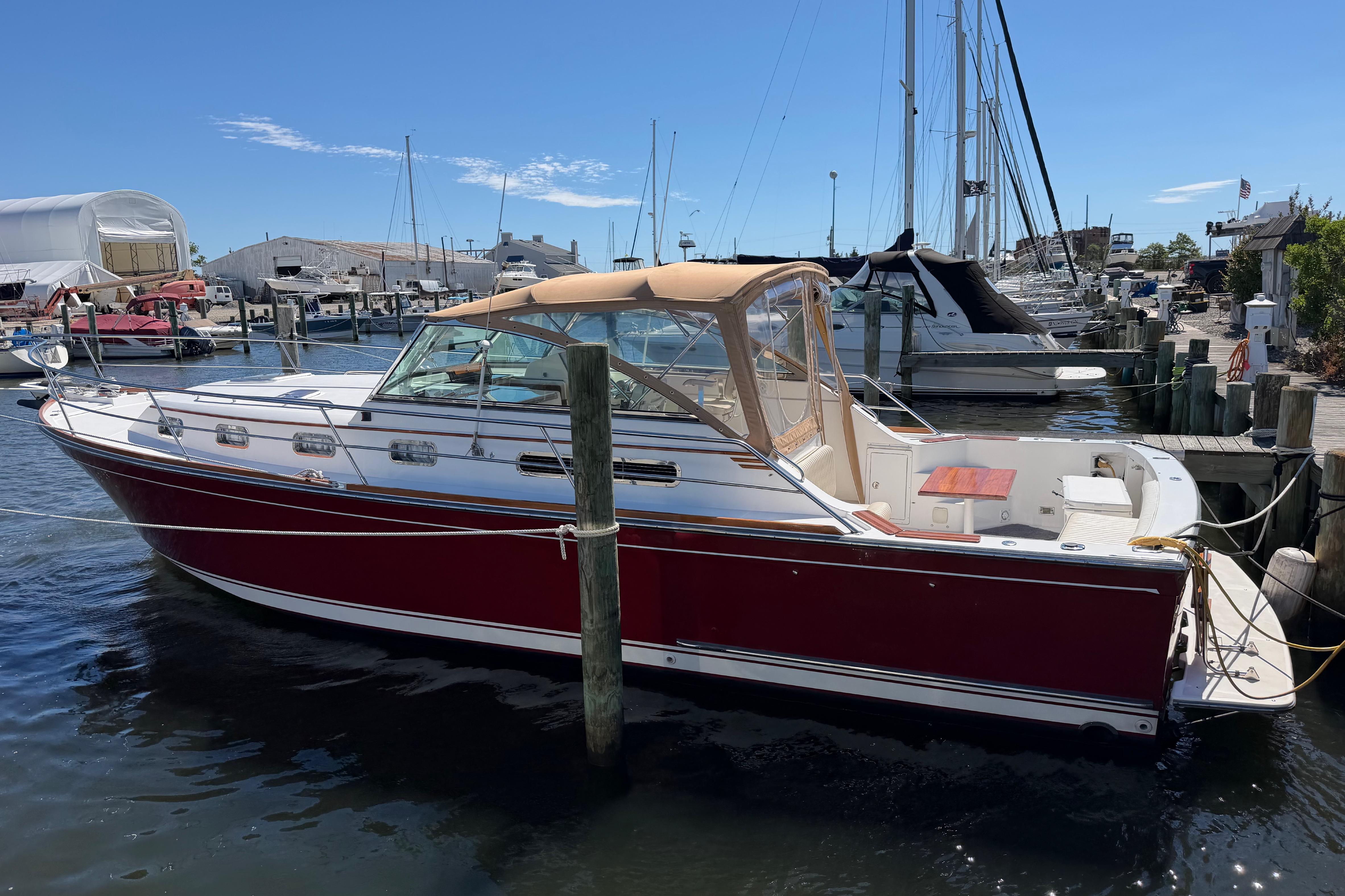 2000 Sabreline 36 Express boat docked at a marina under clear blue skies.