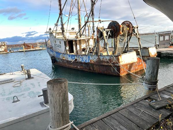 Old 1979 Custom Steel Trawler Dragger docked at a marina, showing signs of rust.