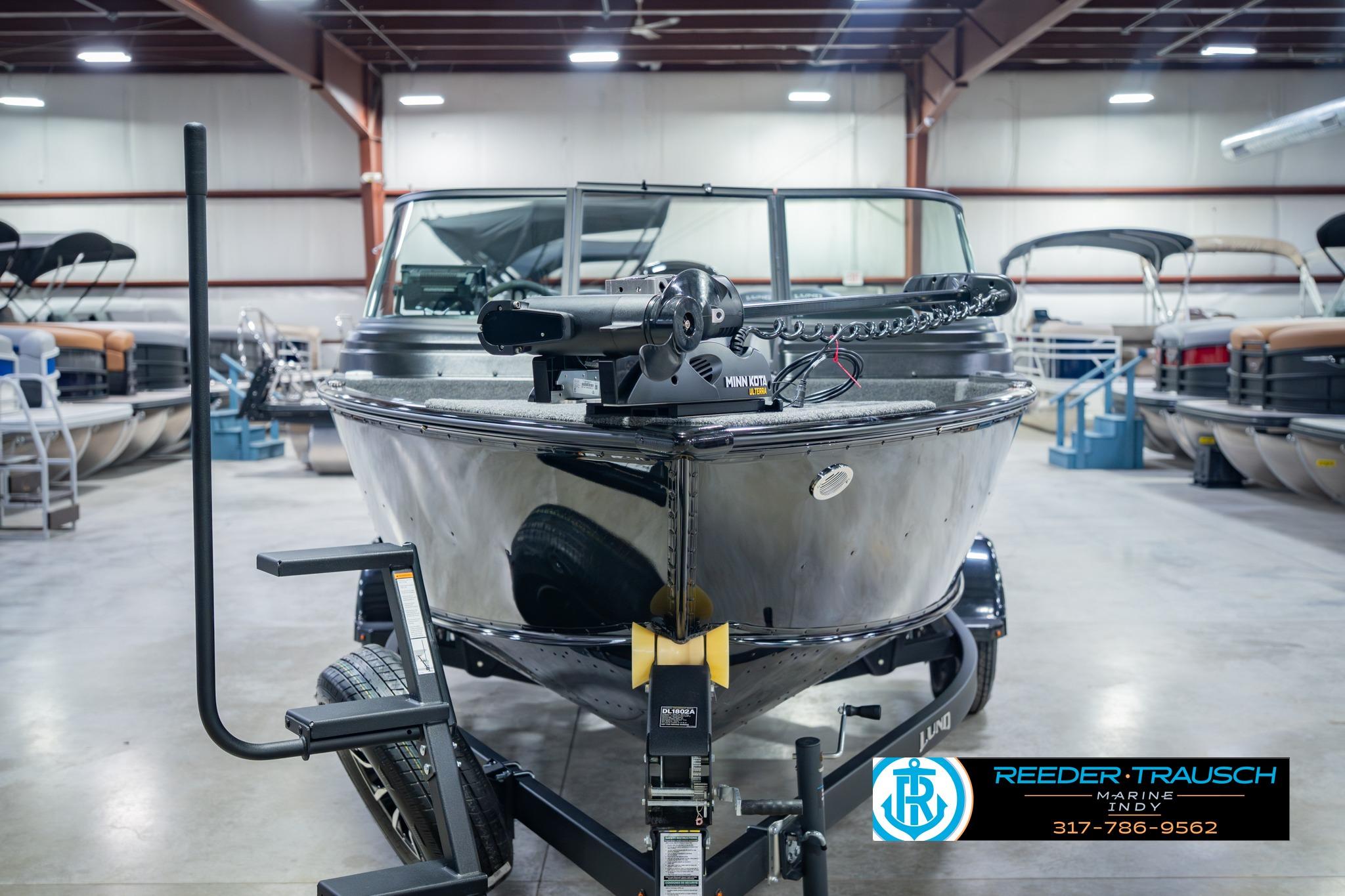 2026 Lund 1775 Impact XS boat on trailer in showroom setting.