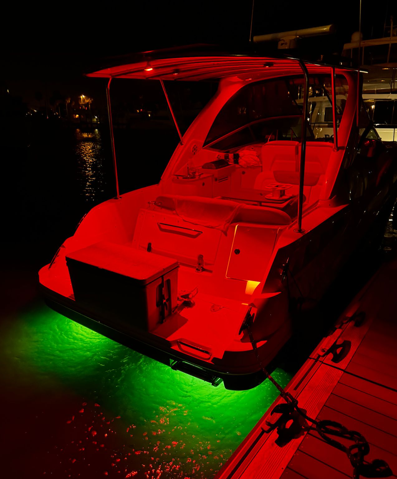 2008 Sea Ray Sundancer 310 with red and green lighting at night.