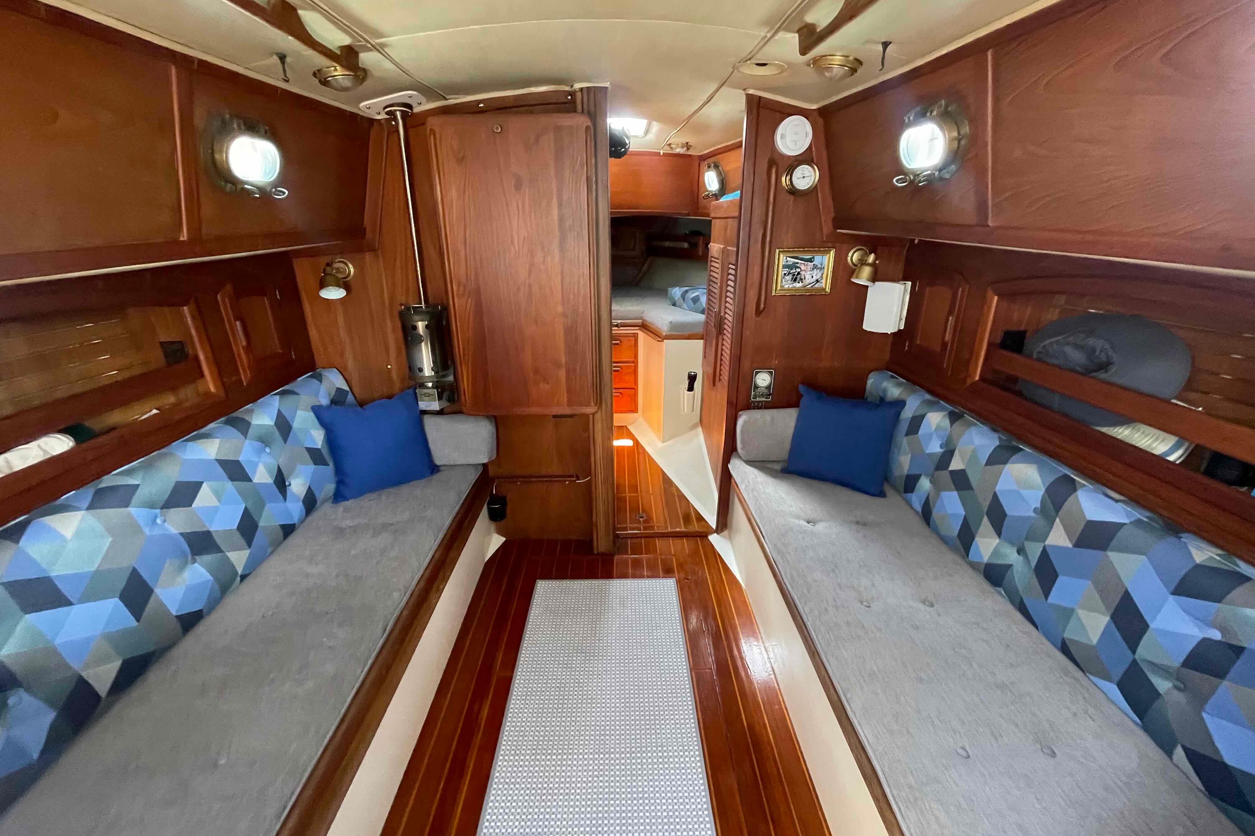 Interior of 1987 Pacific Seacraft 34 sailboat with wooden finish and patterned cushions.