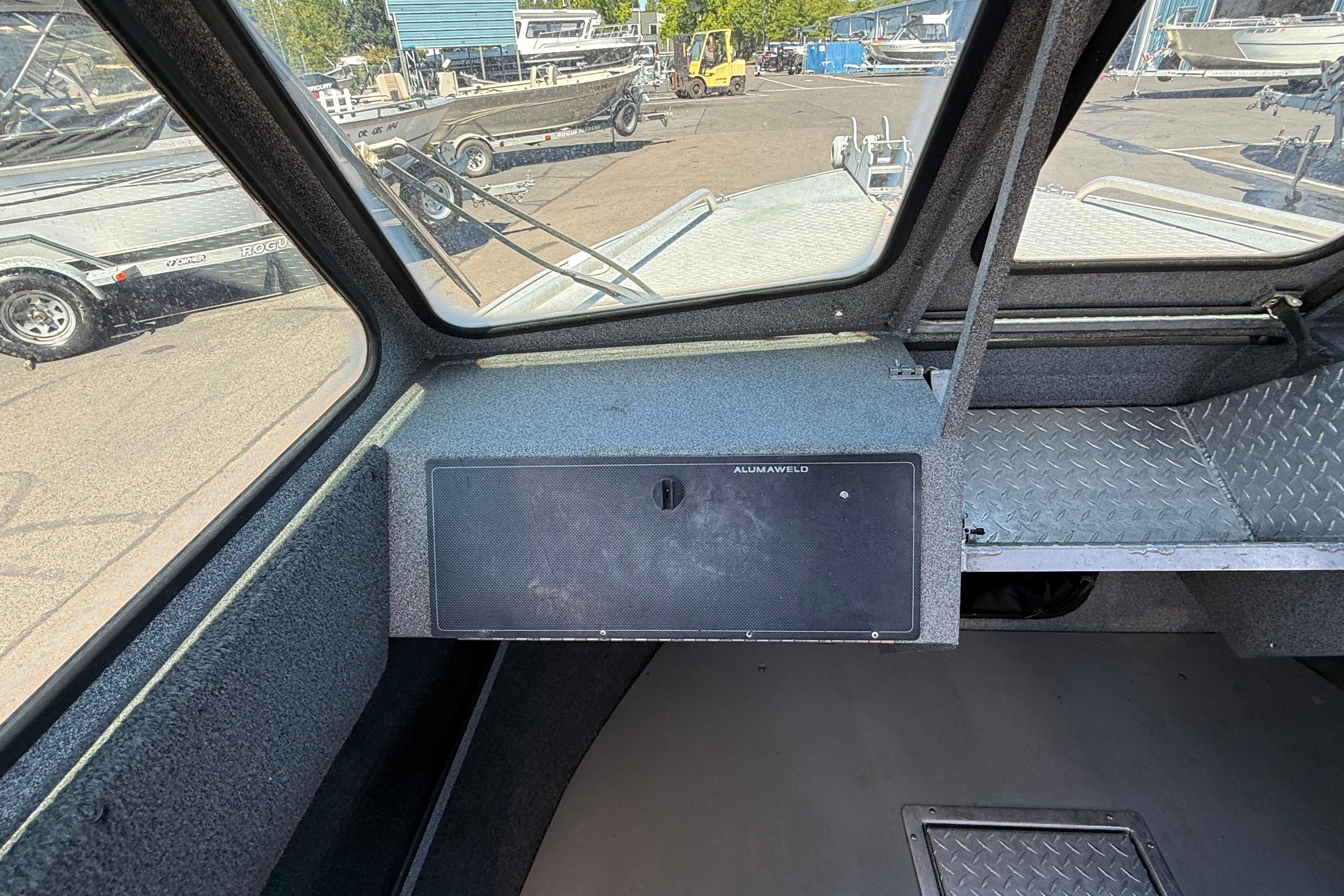 Interior view of a 2004 Alumaweld Intruder Outboard 20 boat, showcasing dashboard and windows.