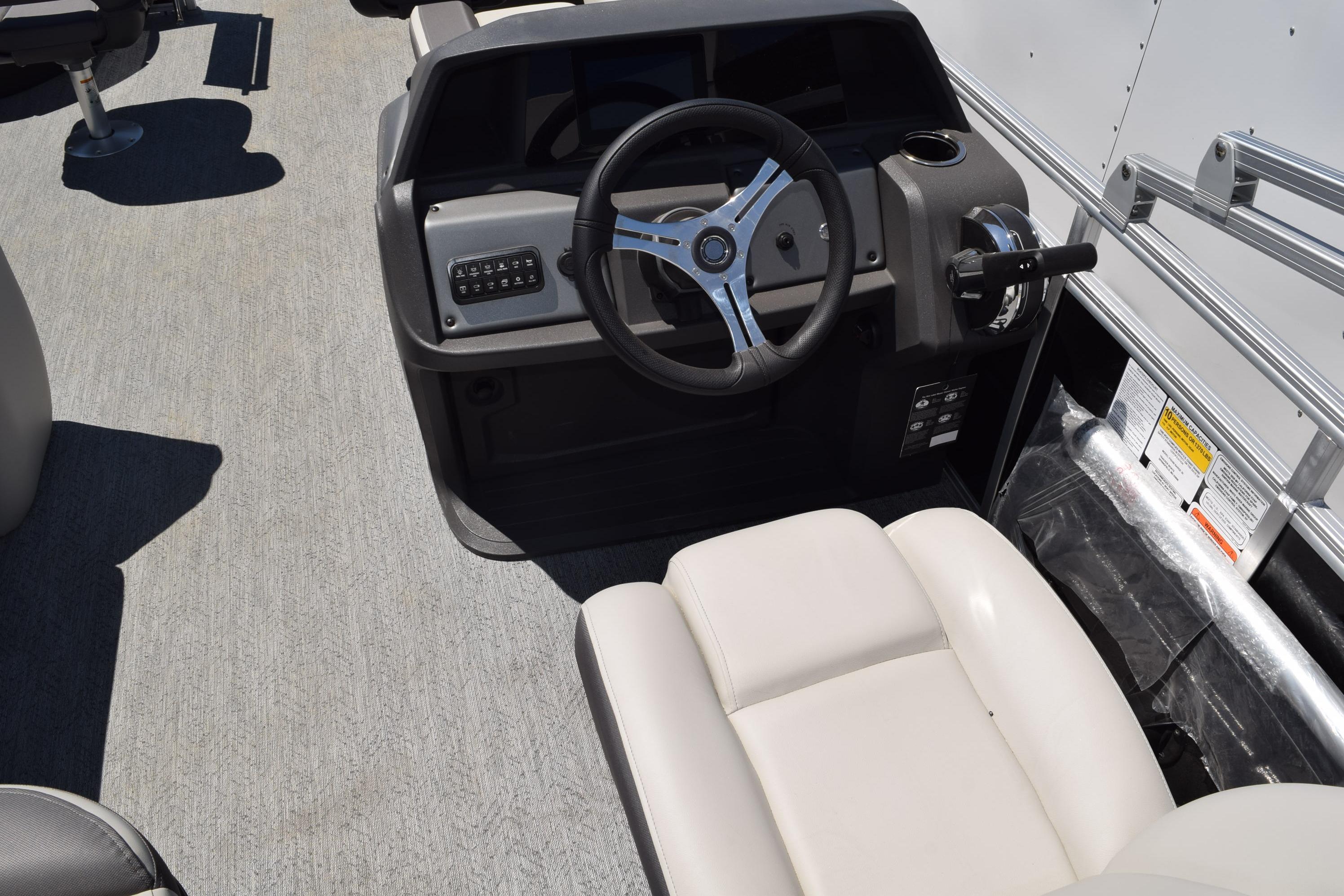 2026 Sun Tracker Fishin' Barge 20 DLX steering console with comfortable seating.