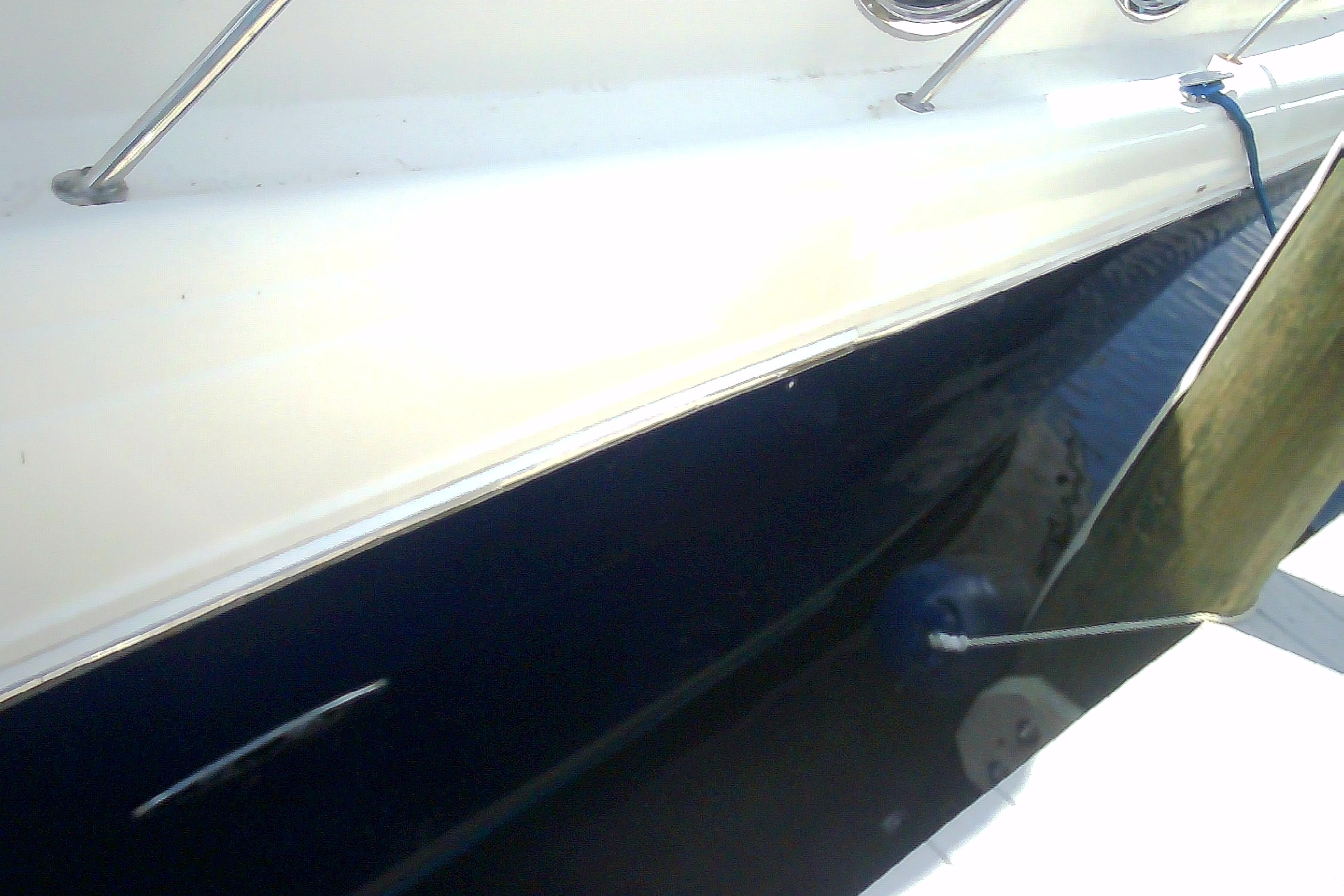 2005 Sea Ray 300 Sundancer boat side view with railing and water reflection.