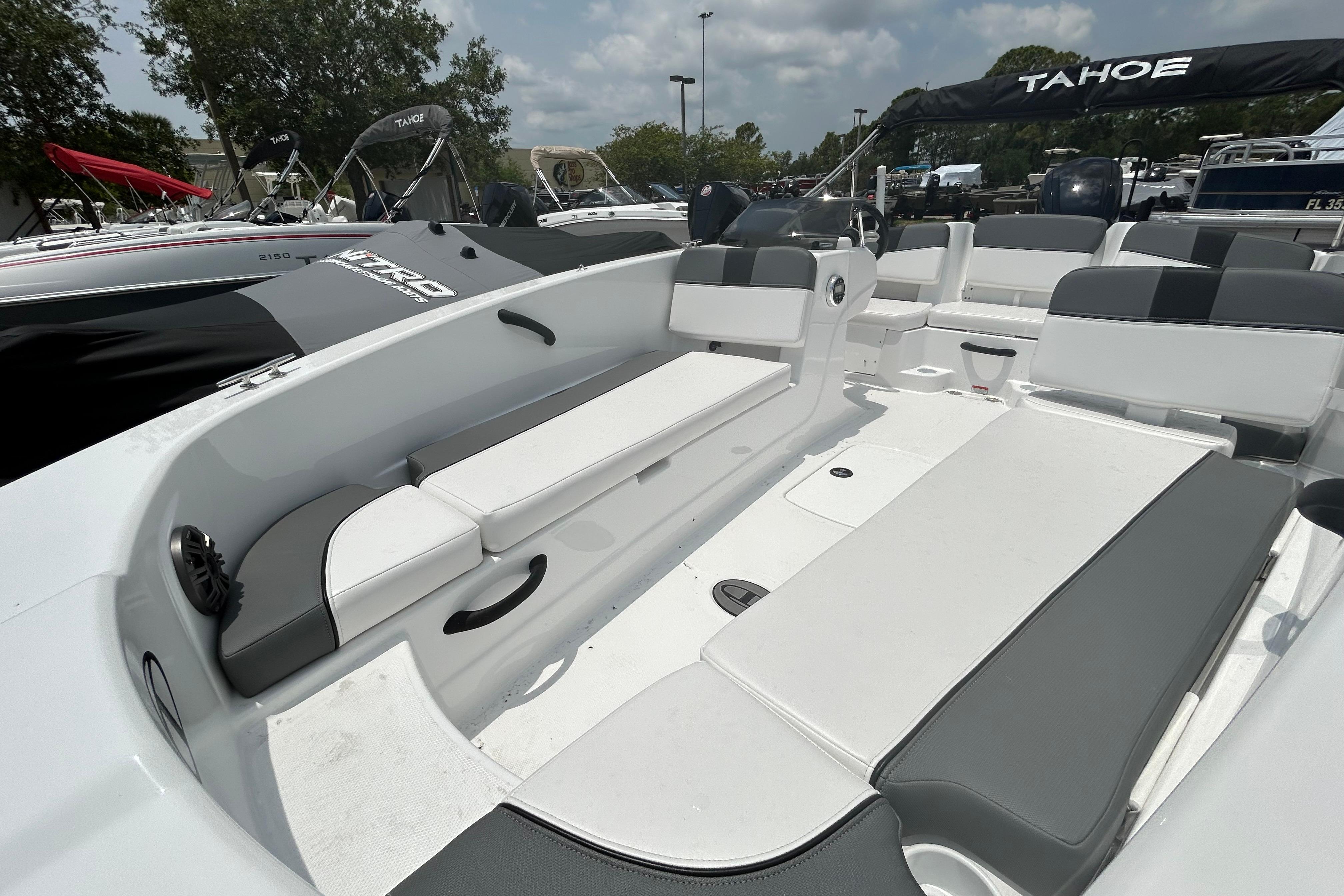 2026 Tahoe T18 boat interior with white and gray seating, parked outdoors.