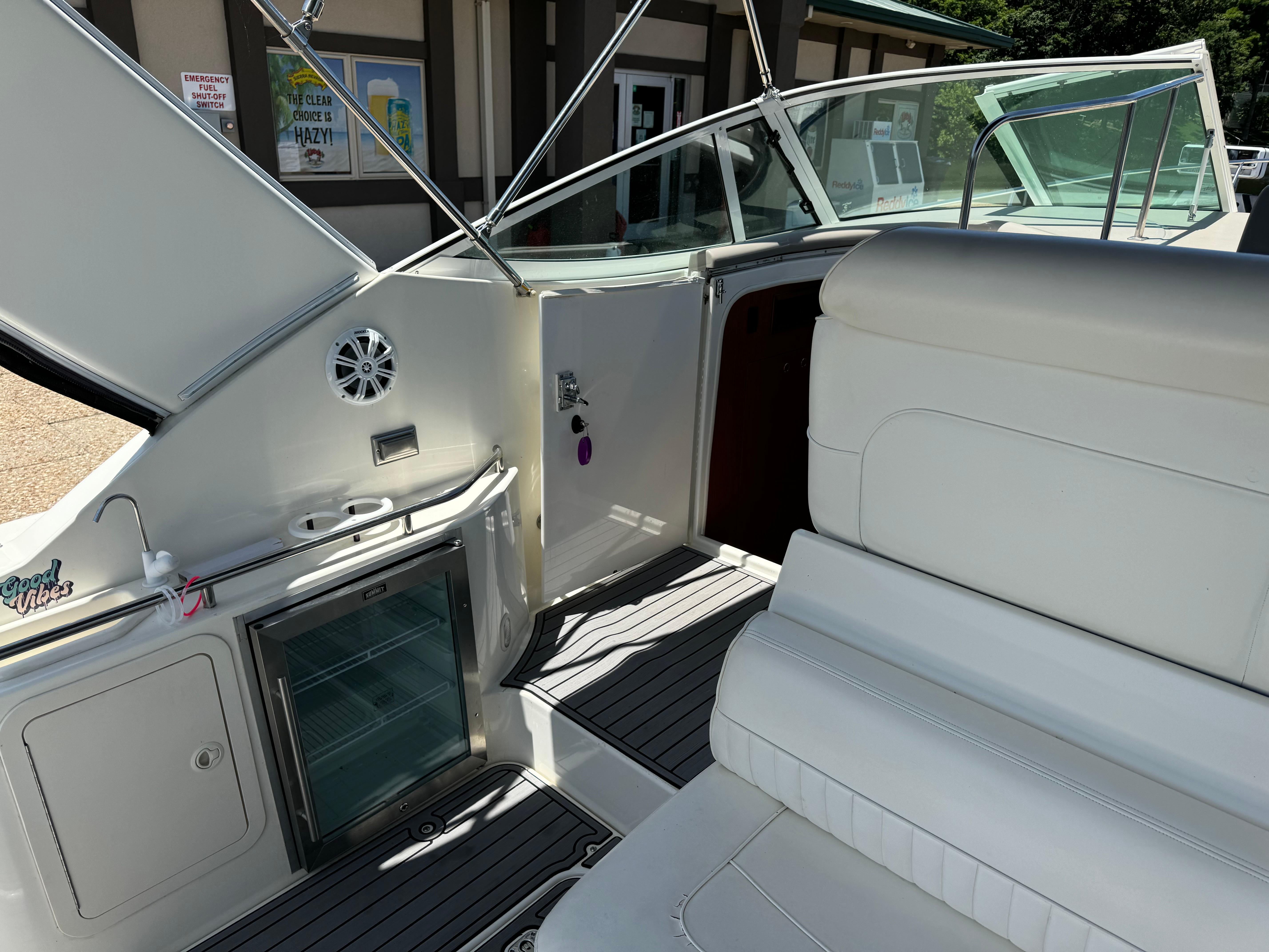 2004 Cruisers Yachts 320 Express interior with seating and mini fridge.