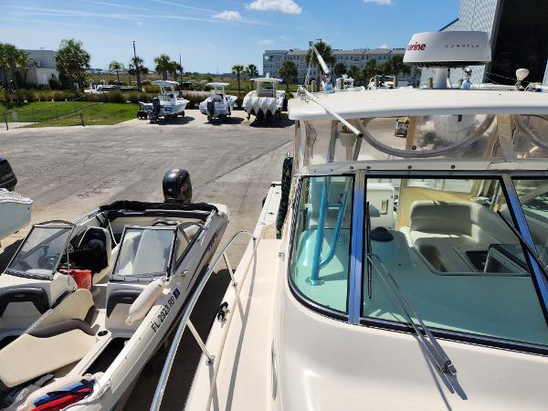 2005 Pursuit 3070 Offshore Center Console boat docked near other boats under a clear sky.