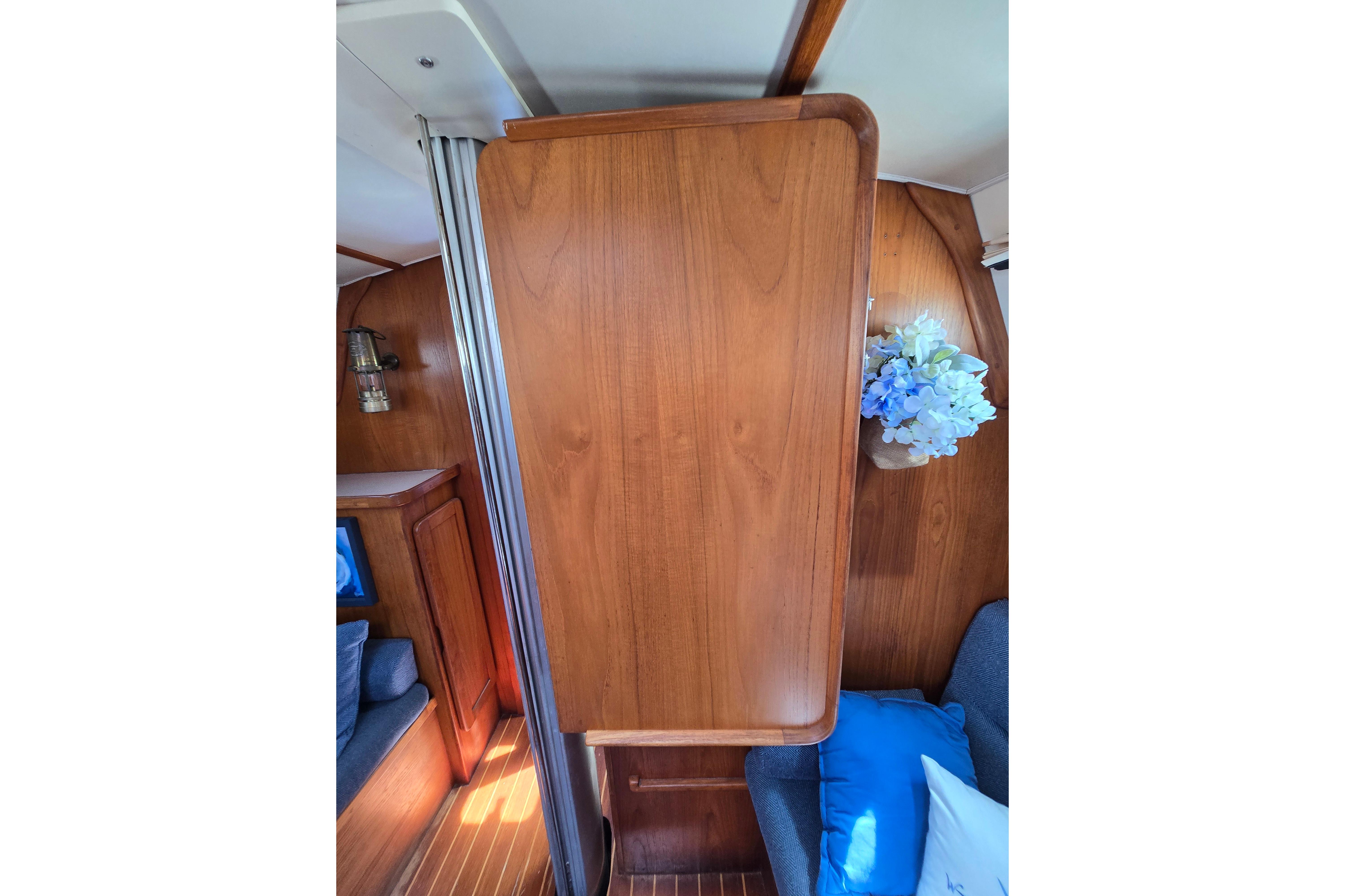 Interior of 1993 Caliber 35 sailboat with wood paneling and blue floral decor.