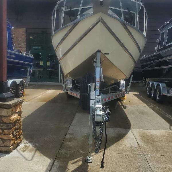 2024 Spartan 2600 Olympia boat on a trailer in a showroom.