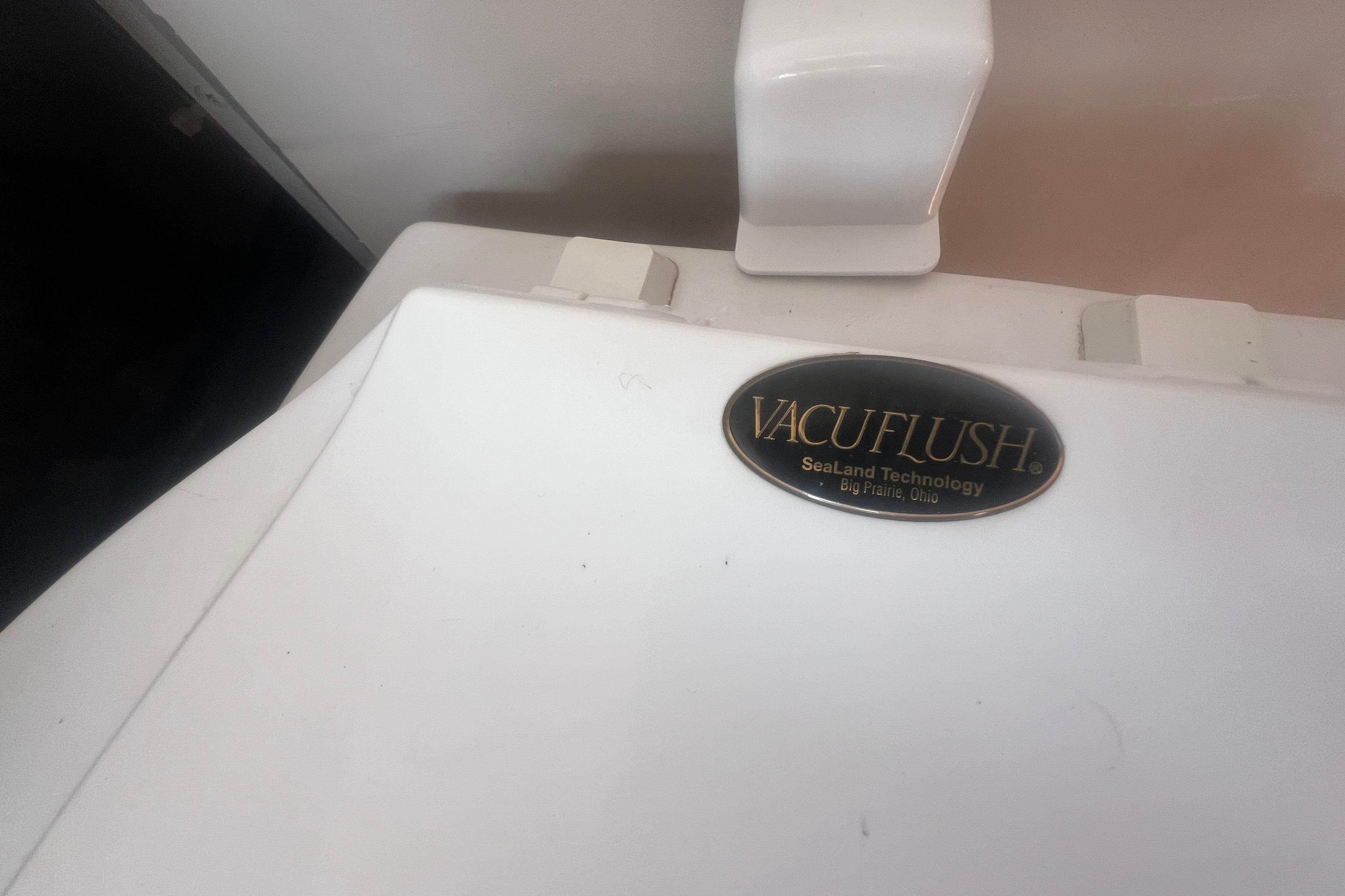 Vacuflush toilet system on 2002 Hurricane SunDeck 260 OB boat, SeaLand Technology label visible.