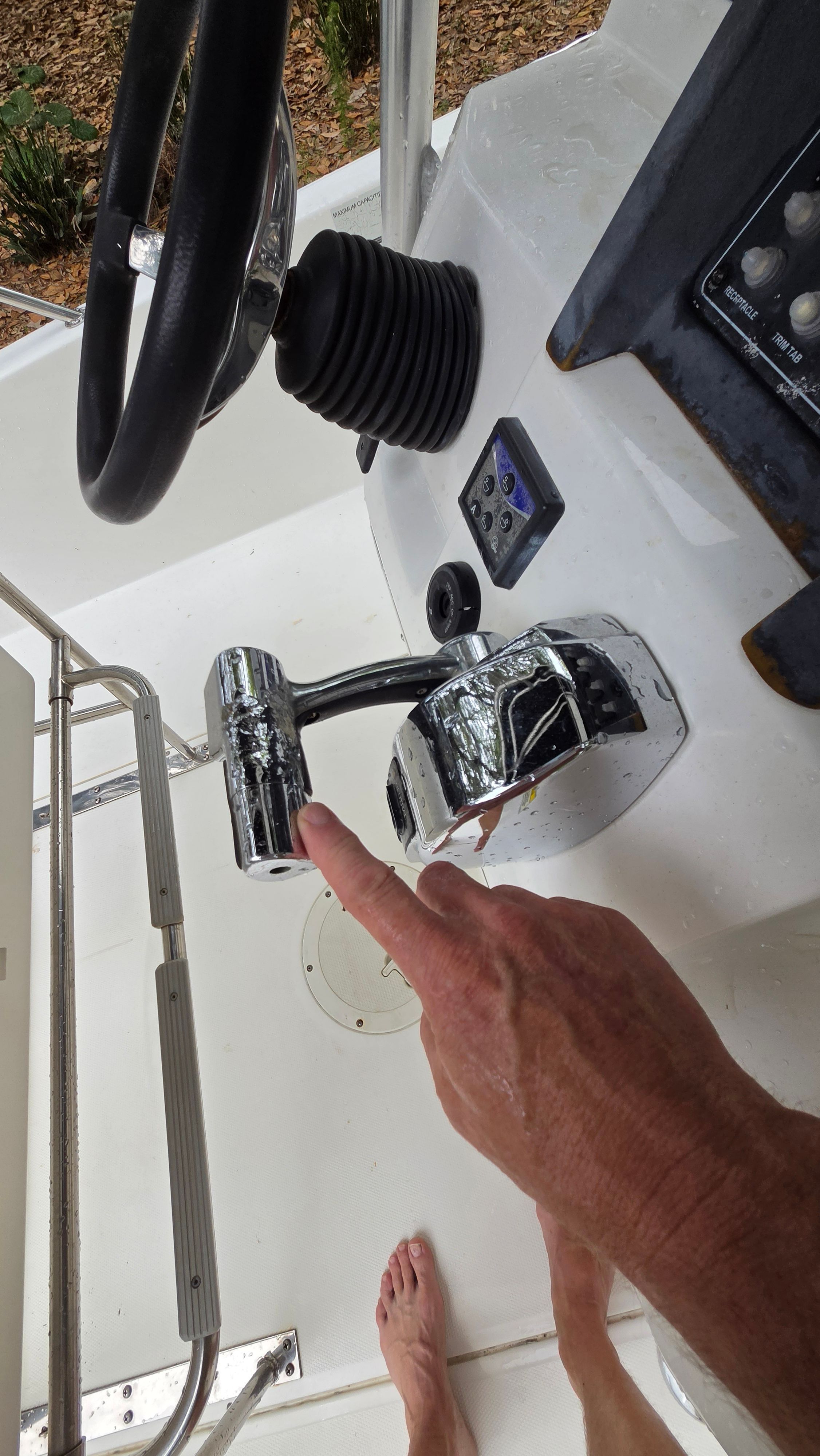 Close-up of a Boston Whaler 230 Dauntless helm with throttle lever and controls.