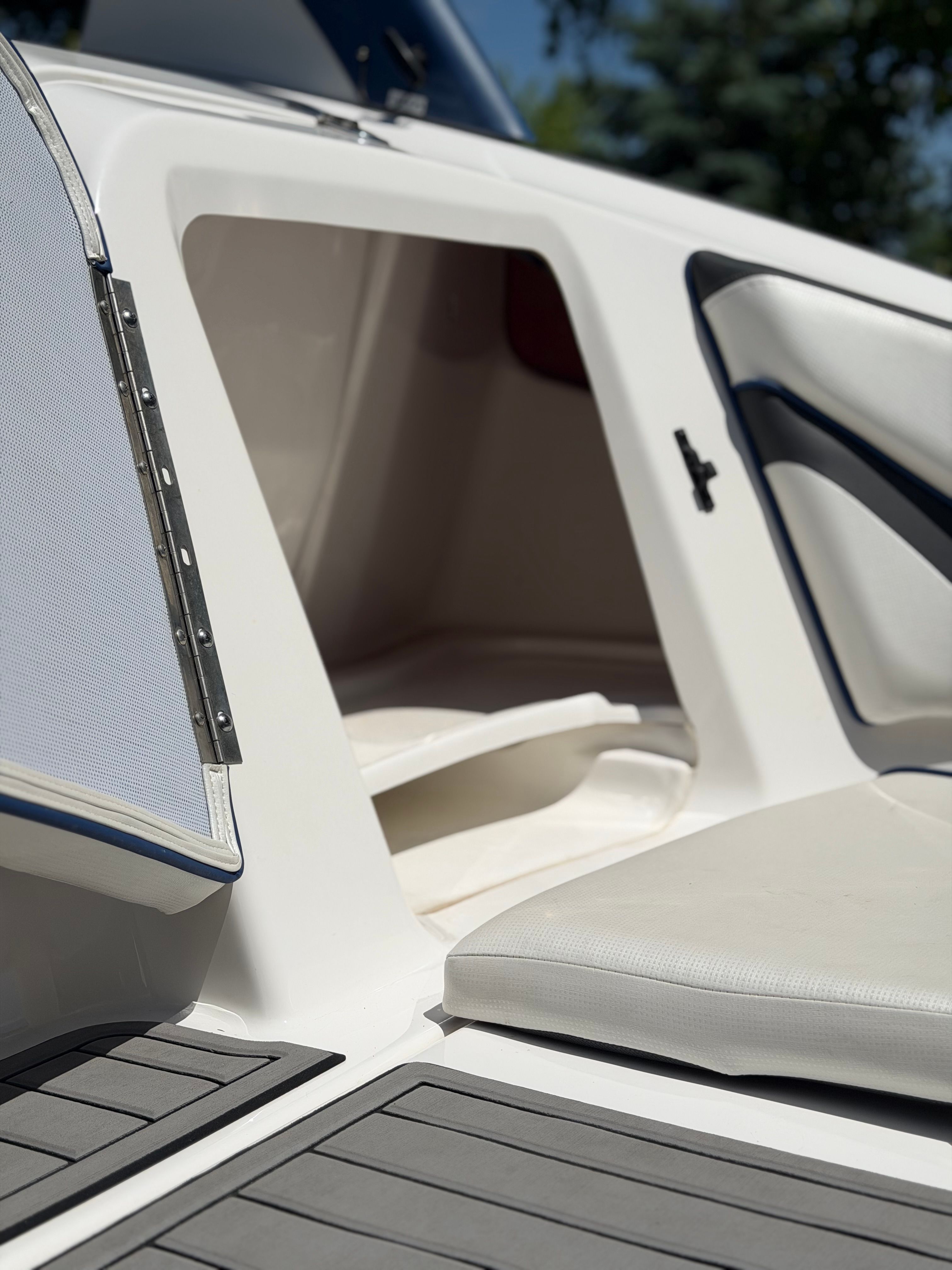 Close-up of a white boat with gray flooring and cushioned seating.