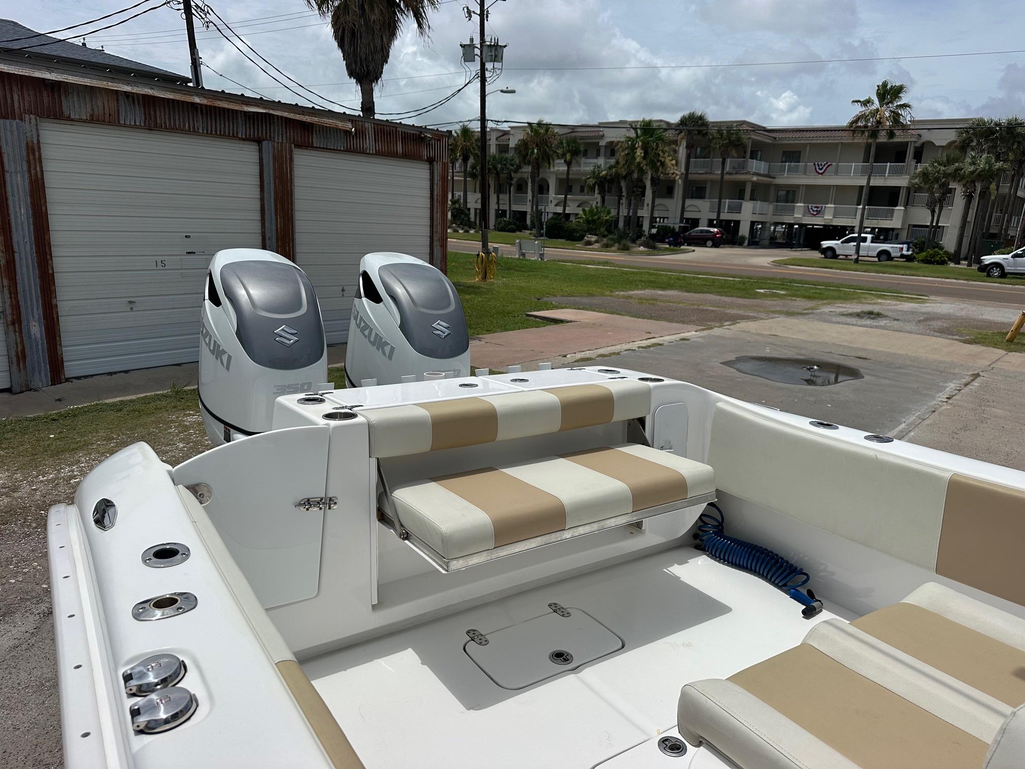 2023 Cape Horn 32xs boat with Suzuki engines, beige seating, and coastal background.