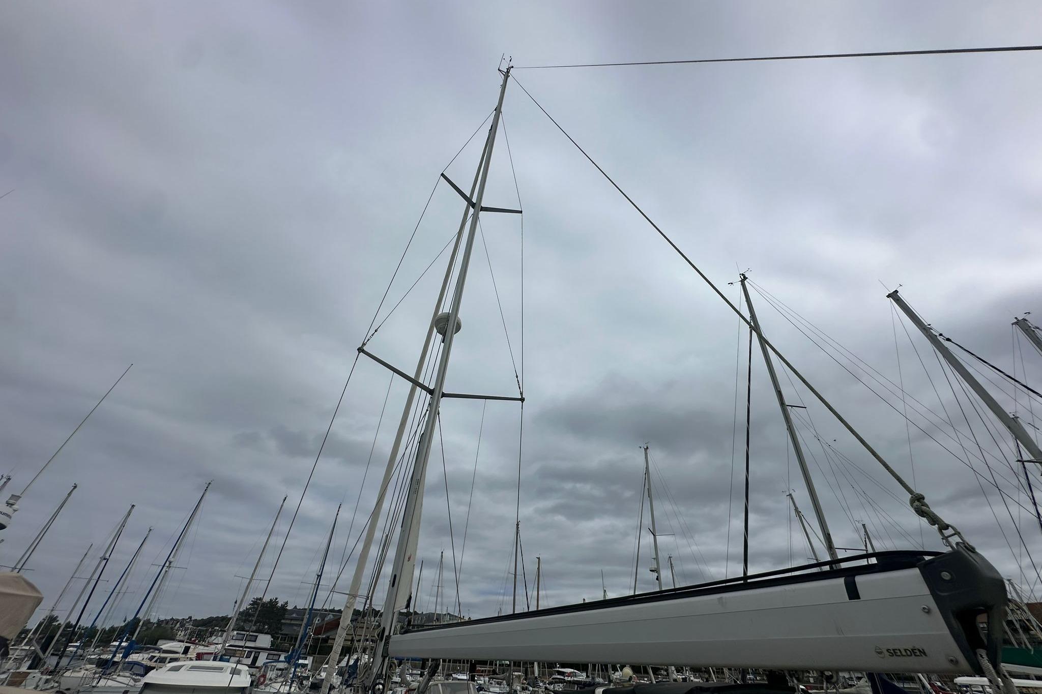 Sailboat masts in a marina under cloudy skies, featuring a 1999 Bavaria Yachts 38 Ocean.