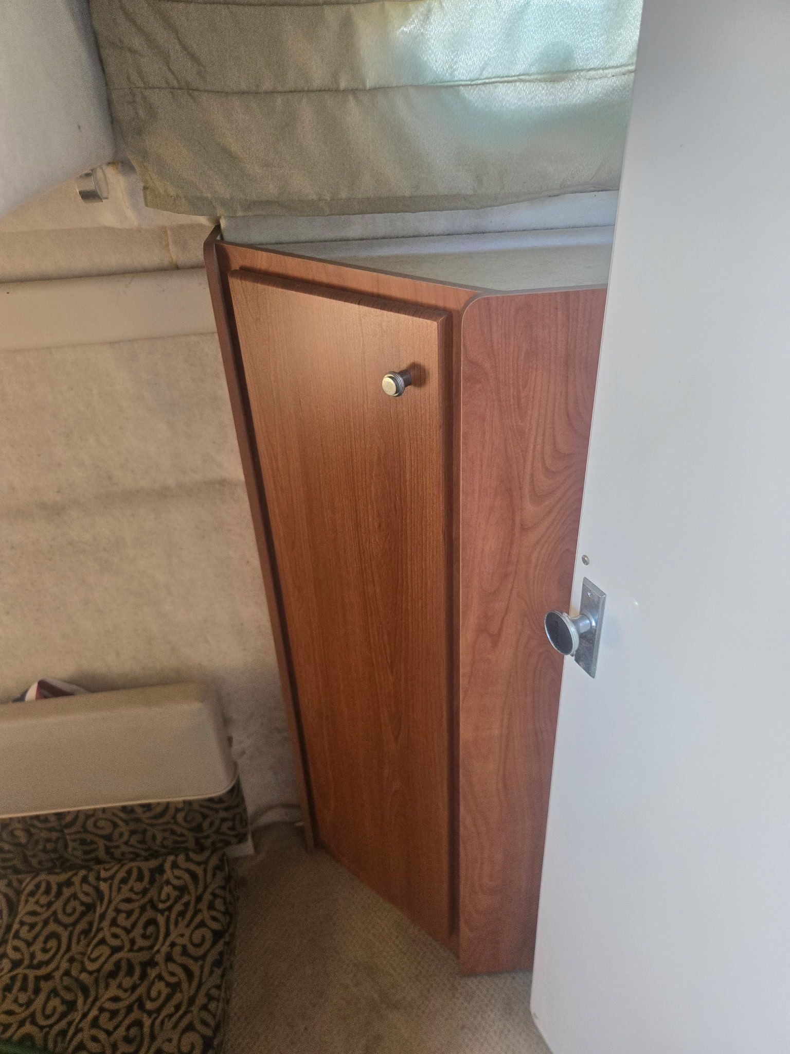 Interior of a 2003 Bayliner 28 boat with wooden cabinet.