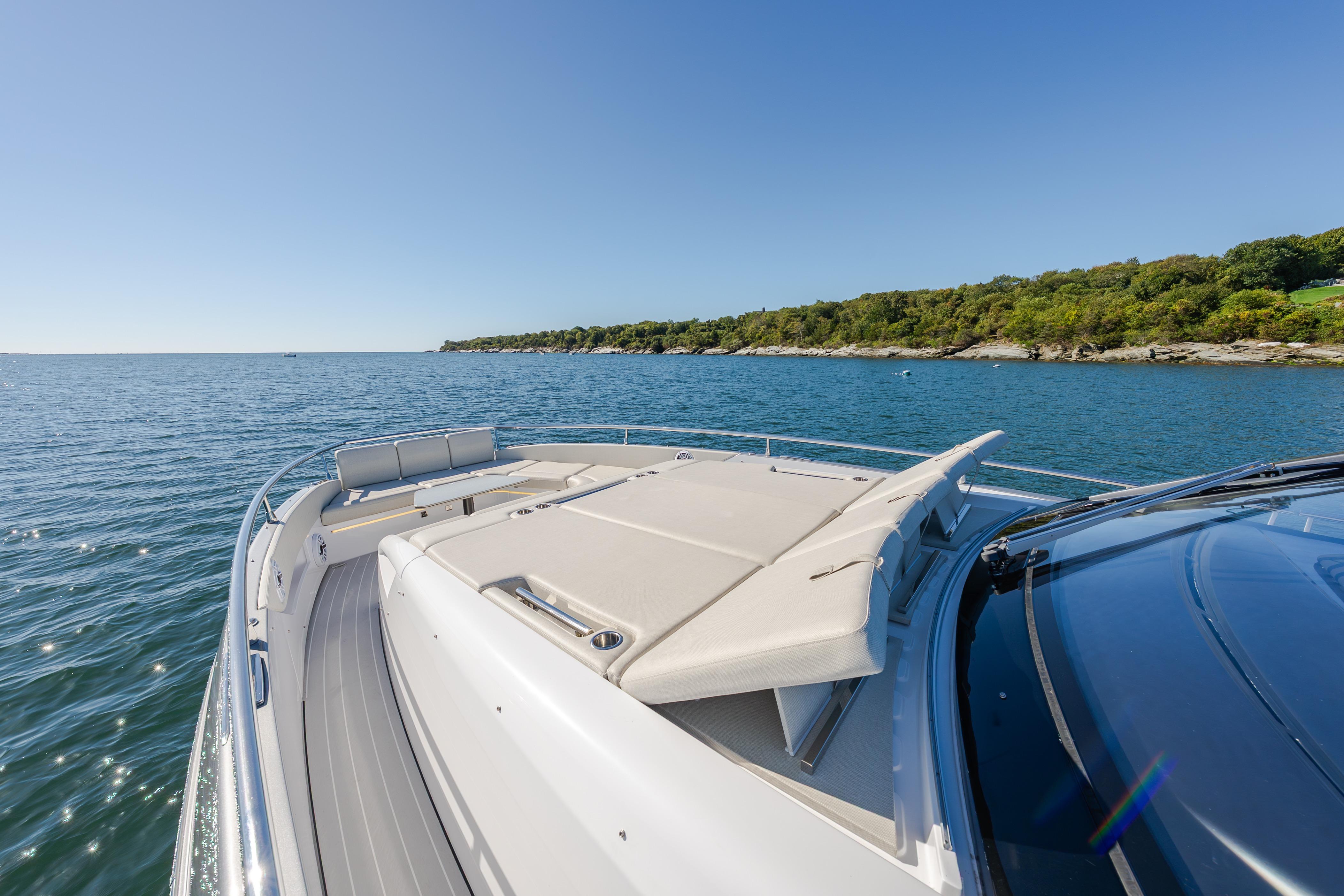 2023 Azimut Verve 47 yacht cruising on a sunny day near a lush coastline.