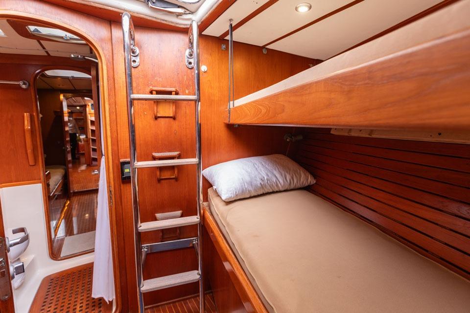 Interior of 1992 Nautor Swan 68 yacht, featuring wooden bunk beds and ladder.