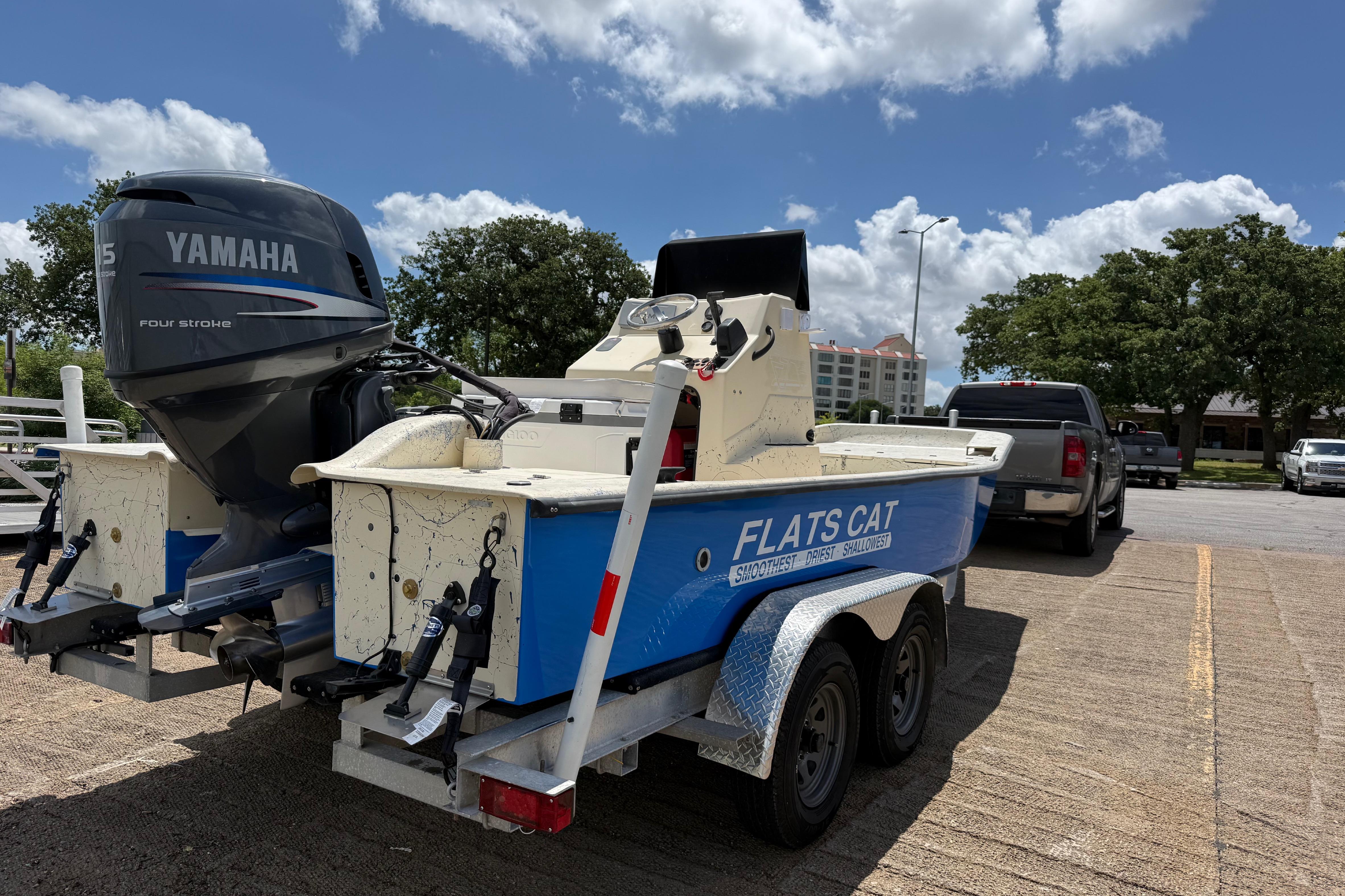 2007 Flats Cat 19 boat with Yamaha engine on trailer, parked outdoors under blue sky.