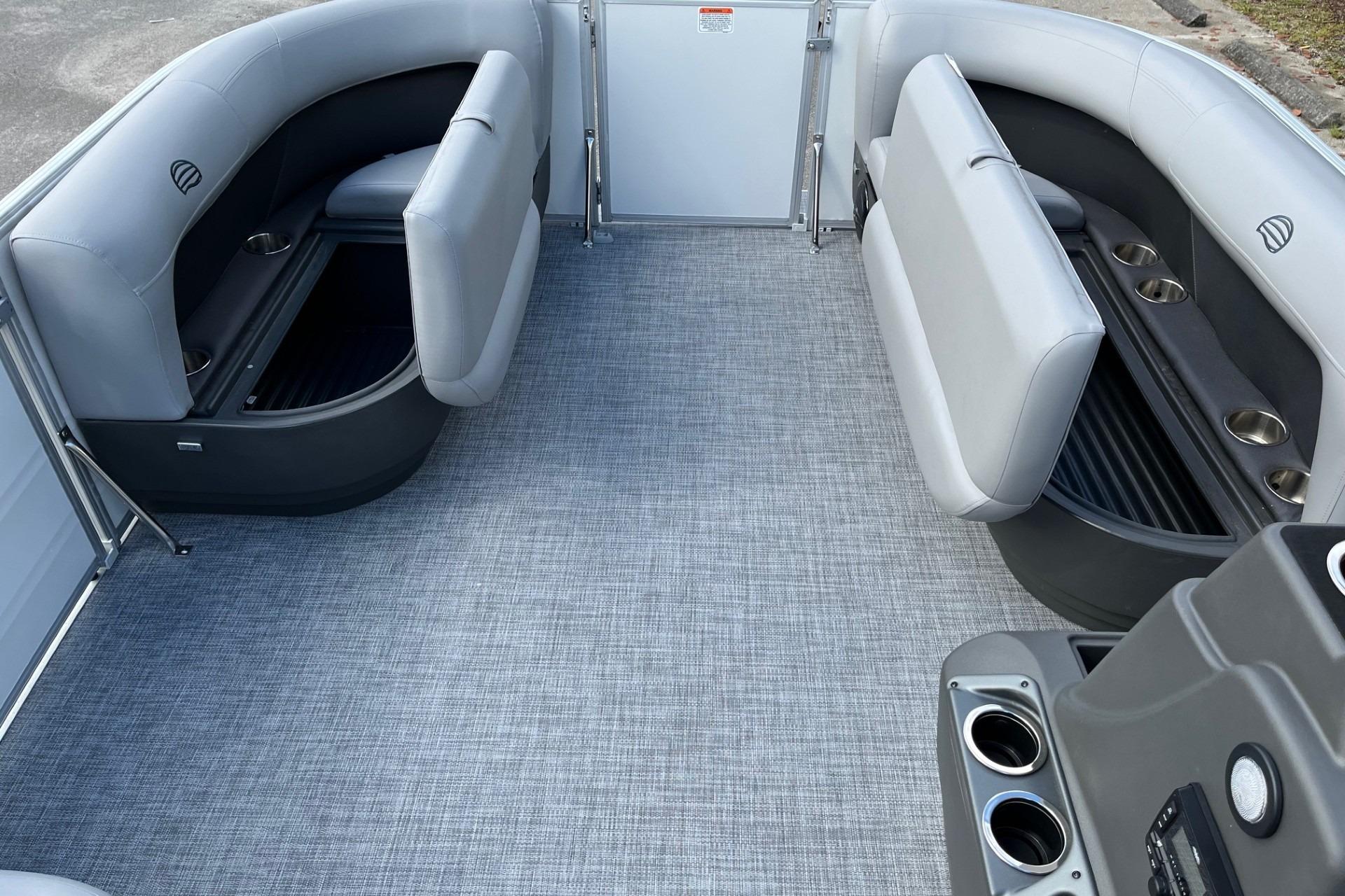 2026 Sun Tracker Party Barge 16 DLX interior with gray seating and cup holders.