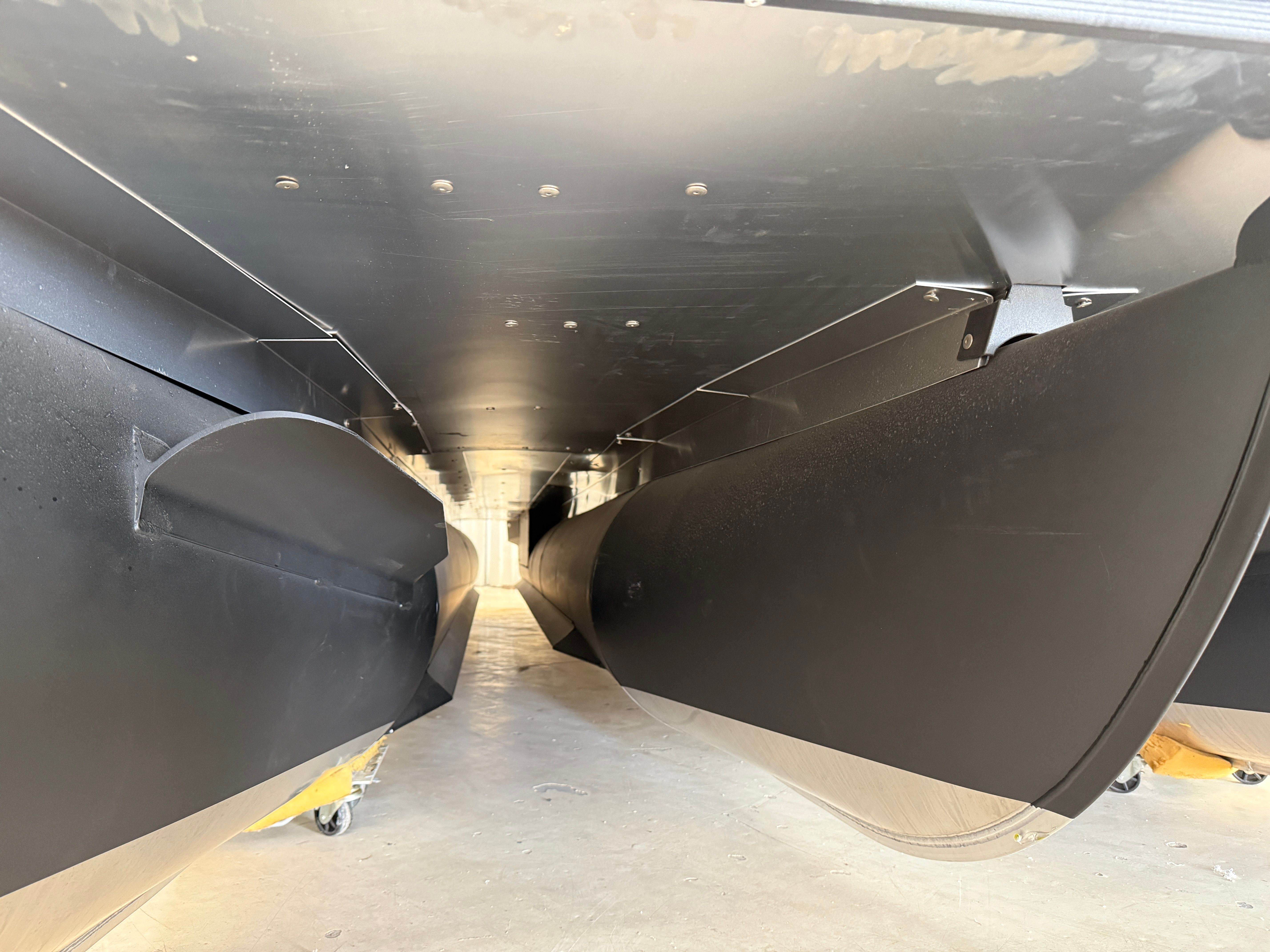 Underside of a Sylvan L3 ULZ DH pontoon boat in a storage area.