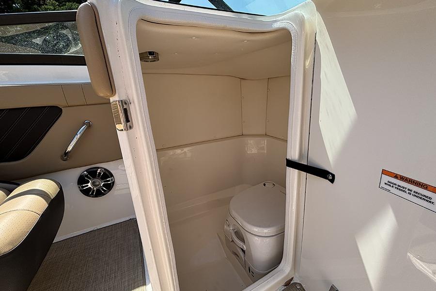 Interior view of 2019 Sea Ray SPX 230 Outboard boat's compact bathroom area.