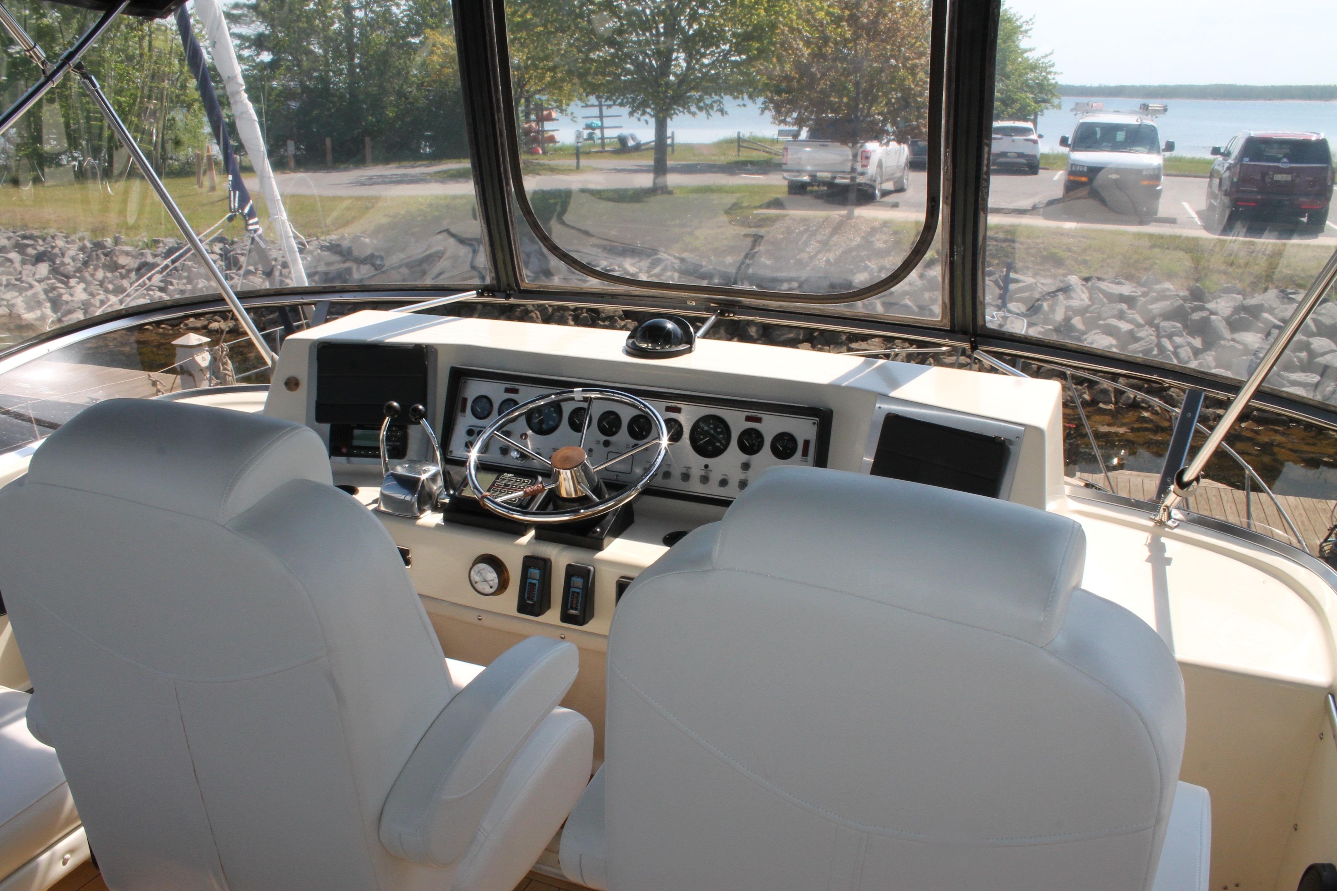 1987 Chris-Craft 427 Catalina helm with dual seats, steering wheel, and control panel.
