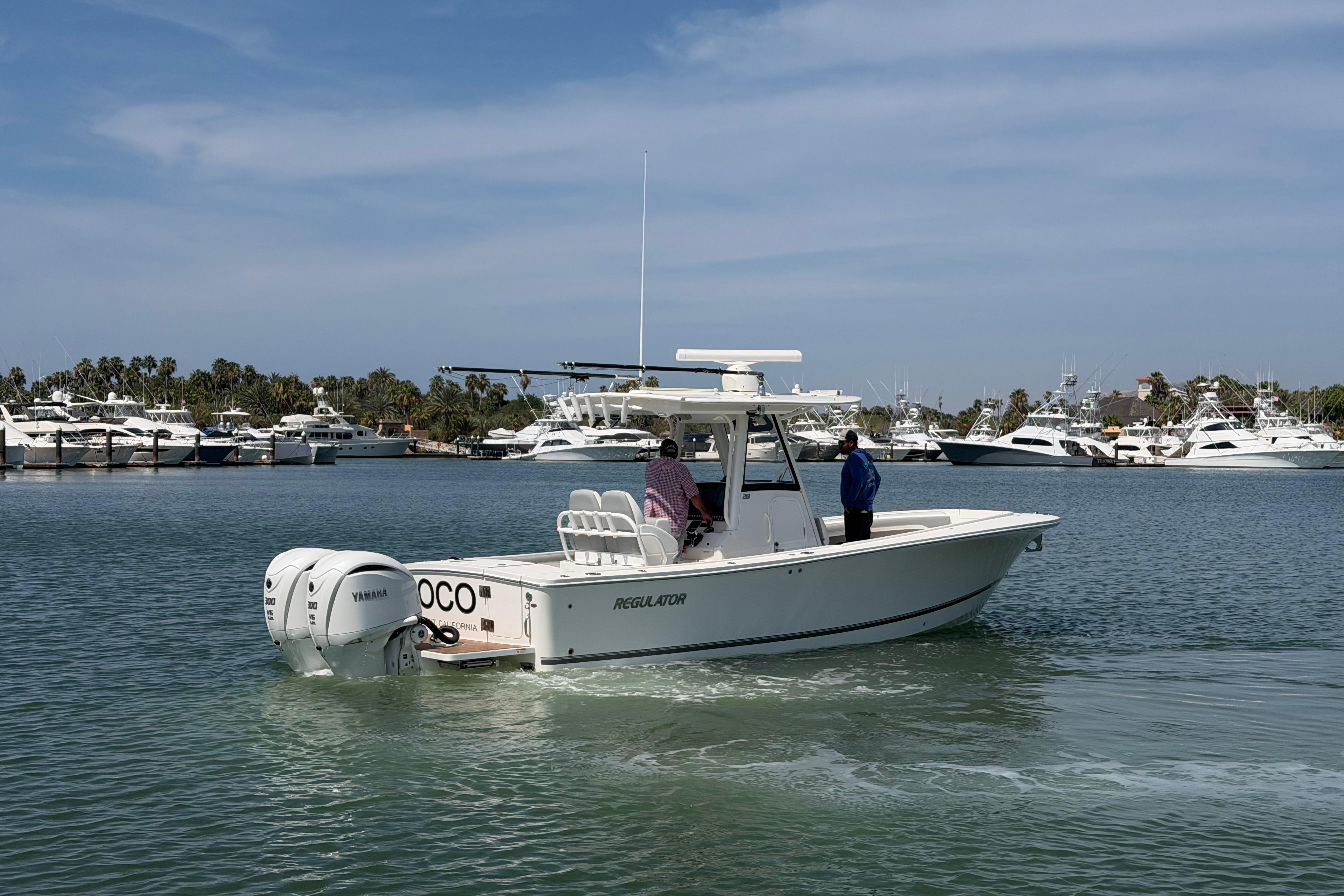 2022 Regulator 28 boat cruising in a marina with multiple yachts in the background.