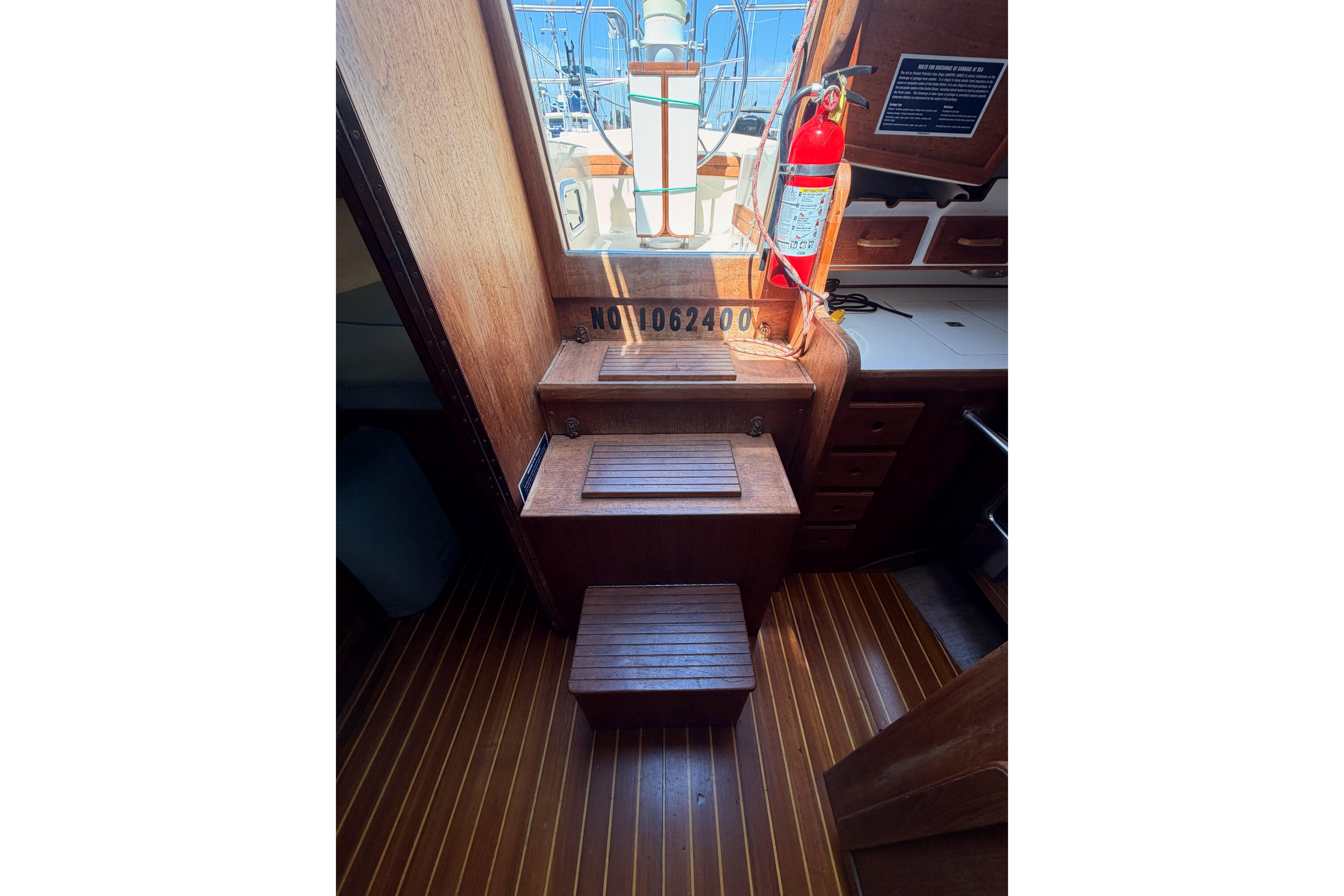 Interior of 1991 Caliber 33 sailboat with wooden steps and fire extinguisher.