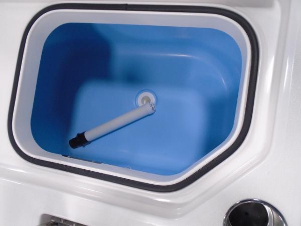 2025 Caymas 26 HB boat livewell with blue interior and white drain pipe.