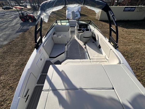 2025 Sea Ray SPX 230 OB boat interior with seating and helm, parked on grass.