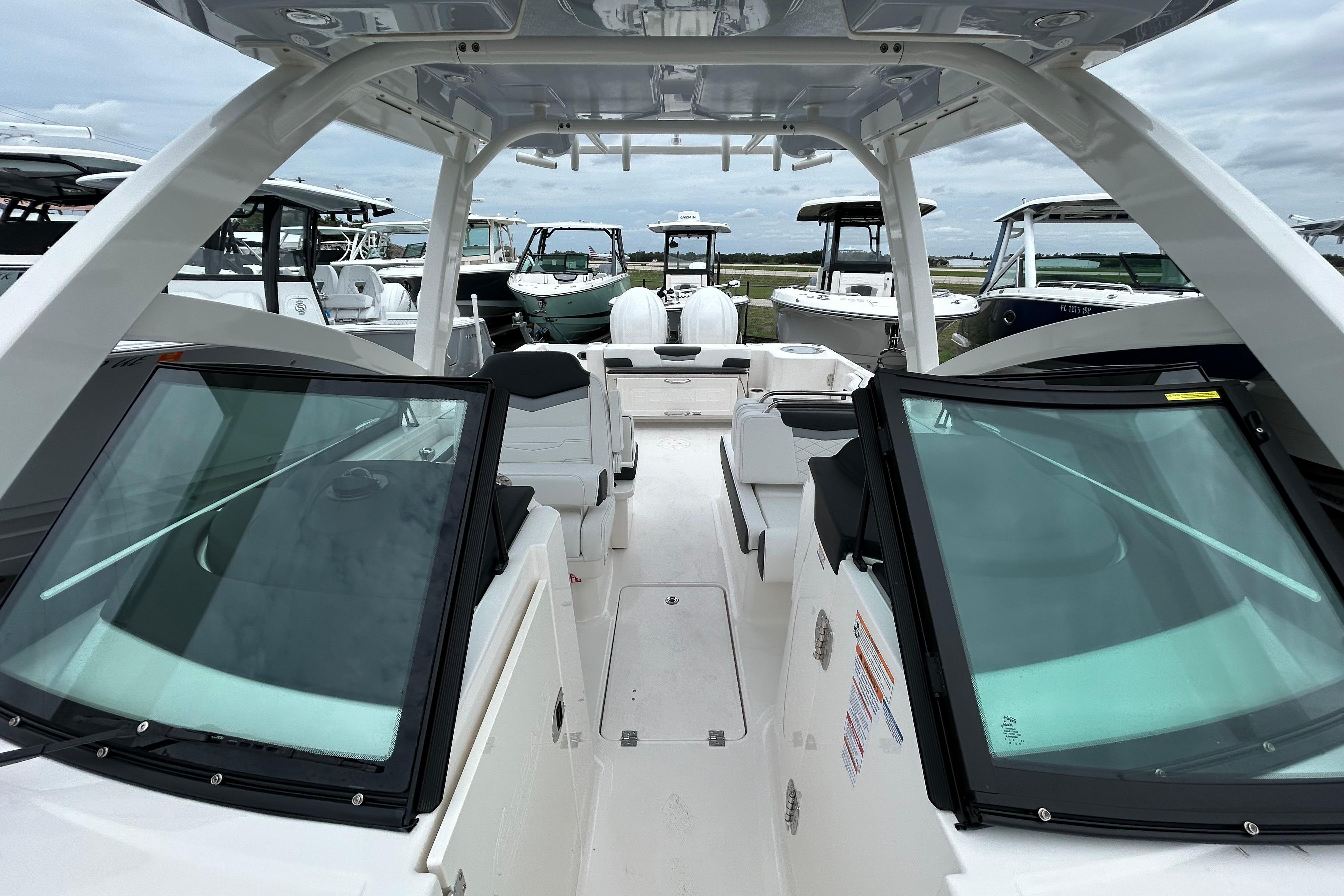 2026 Robalo R277 Dual Console boat interior with seating and windshield, docked among other boats.