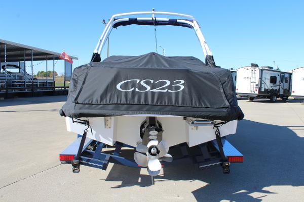 2025 Cobalt CS23 boat with cover, parked on trailer in sunny marina.