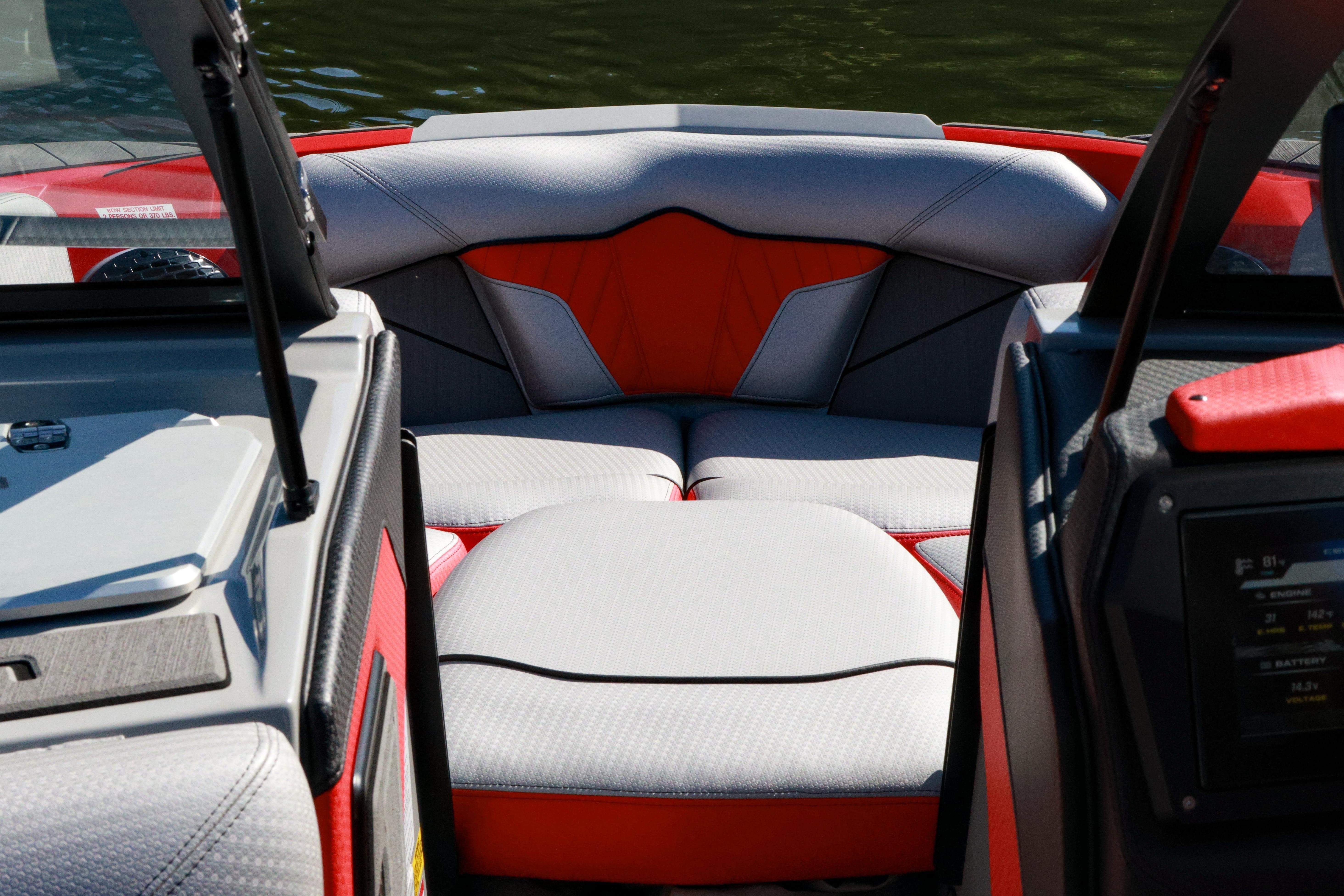 Interior view of 2024 Centurion Fi23 boat, featuring sleek red and gray seating.