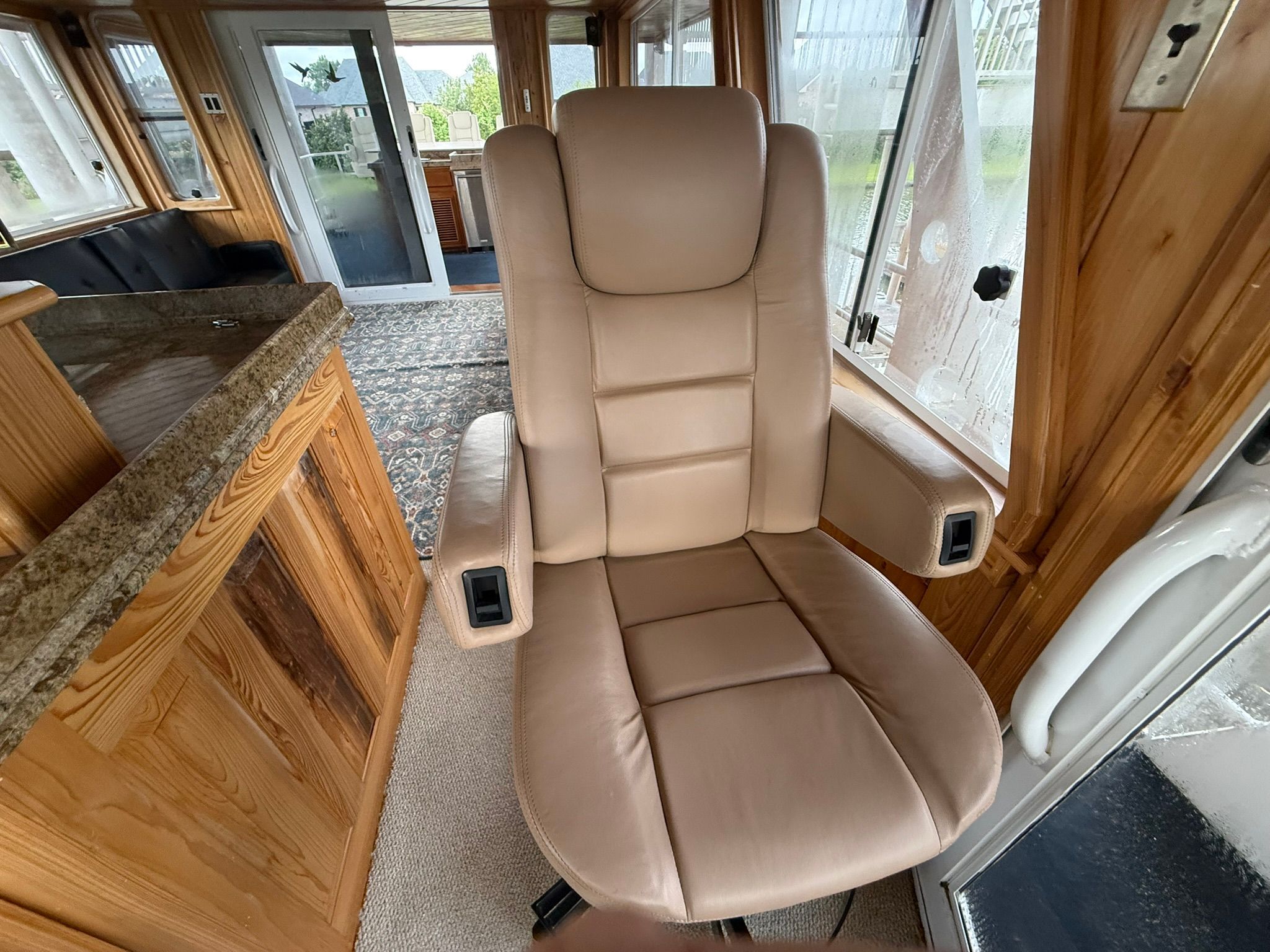 Luxurious leather chair in an elegant boat interior with wood accents and carpeted floor.